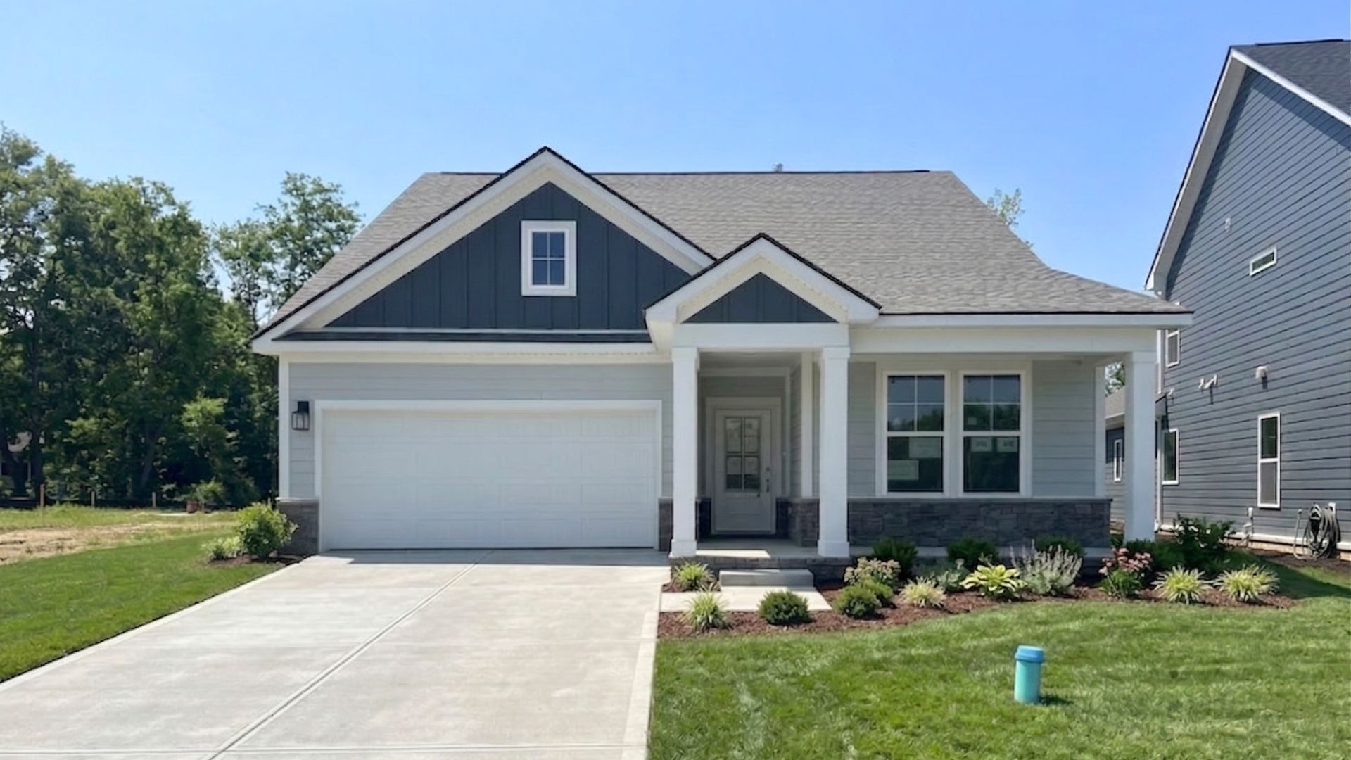 Home with two-tone blue siding and accents, covered front porch and entry