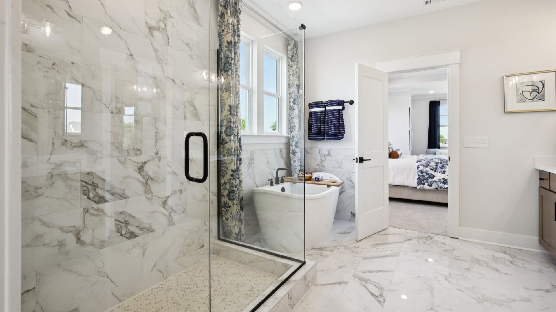Tiled floor, free-standing tub surround, and shower with glass surround