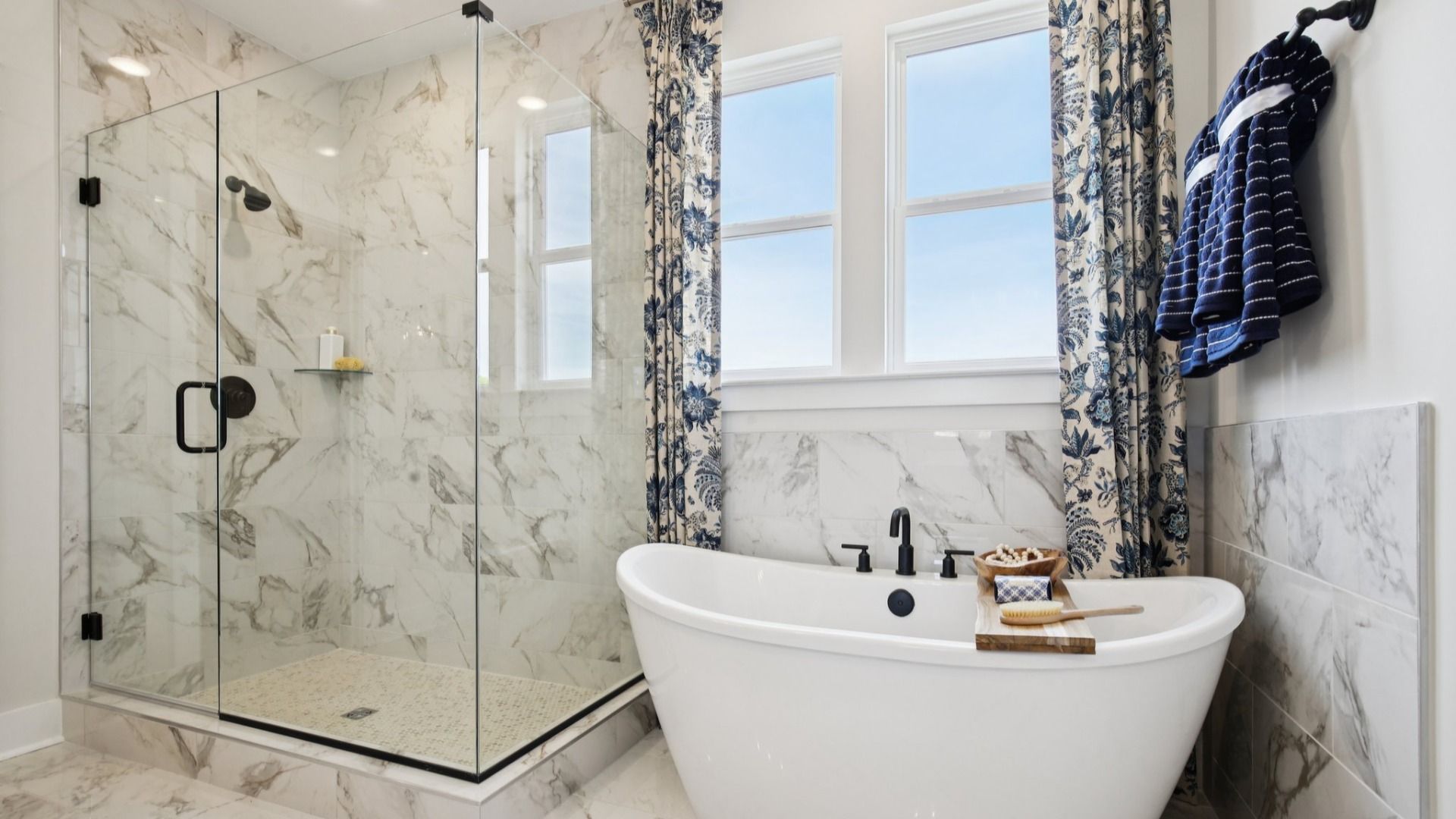 Tiled floor, free-standing tub surround, and shower with glass surround