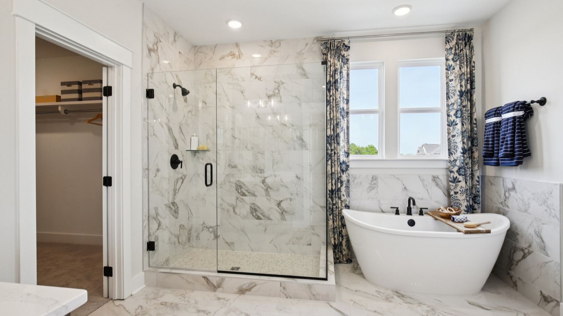 Tiled floor, free-standing tub surround, and shower with glass surround