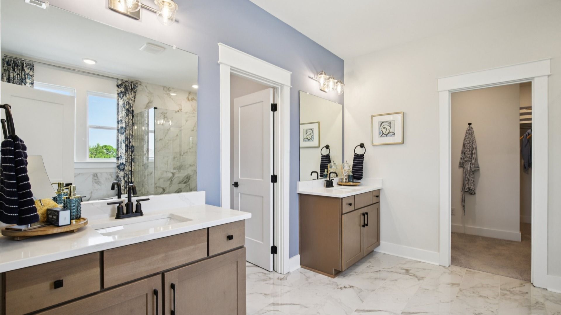 Split double vanity on either side of the water closet, with nearby walk-in closet