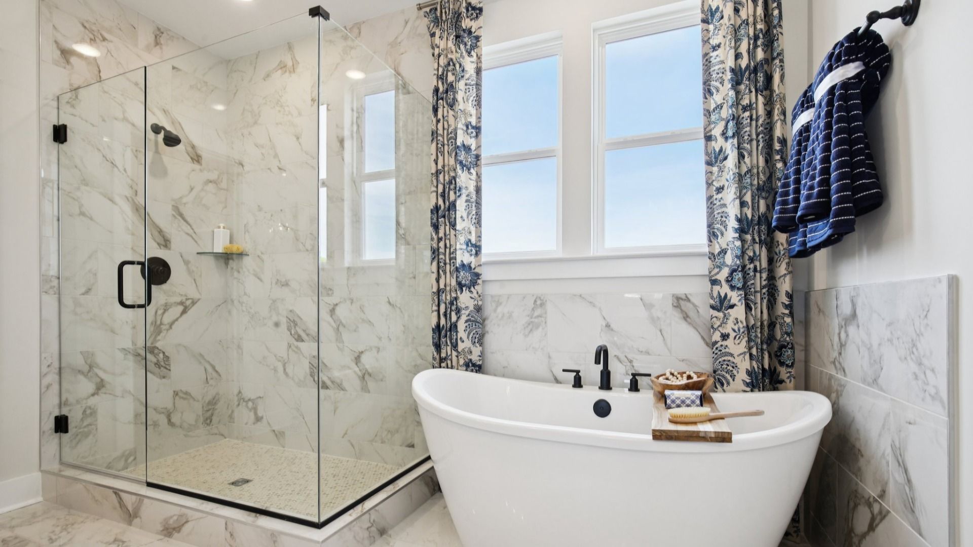 Large primary bathroom with fully tiled floor, shower walls, and freestanding tub surround