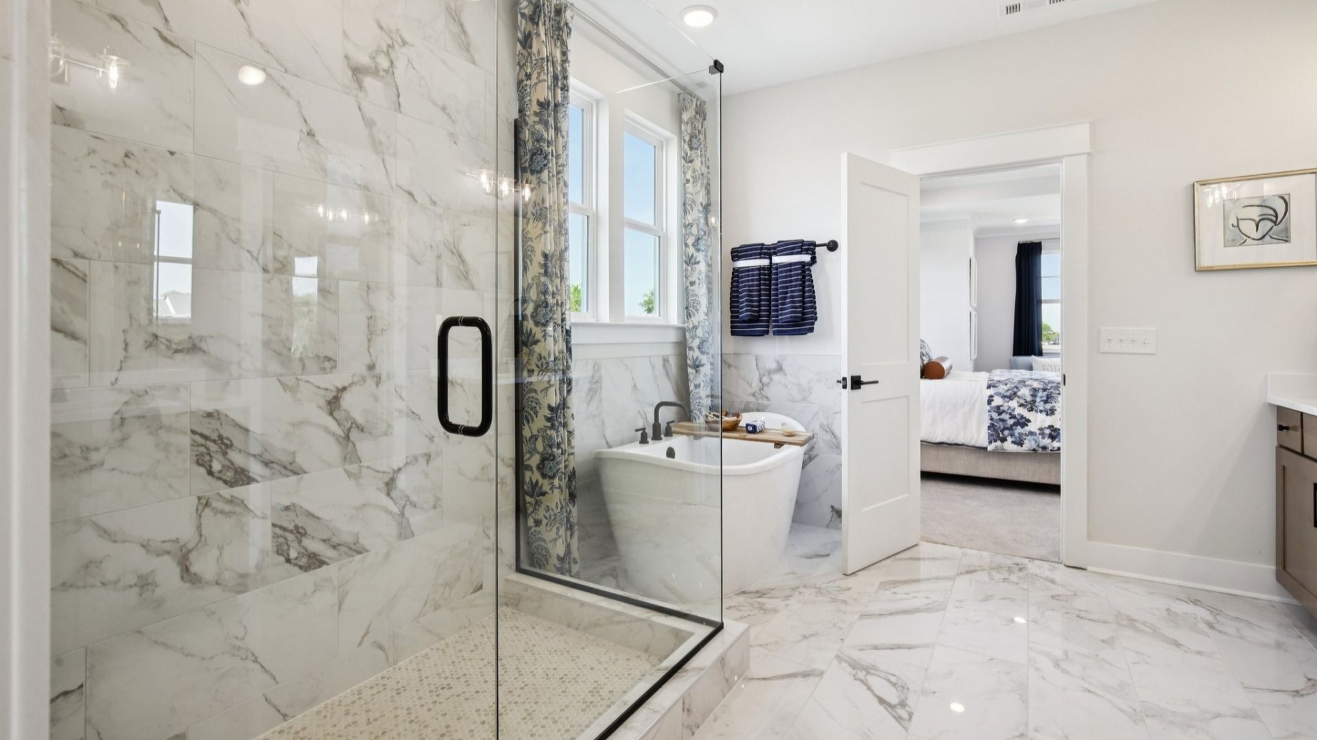 Fully tiled bathroom floor, full shower, and freestanding tub surround.
