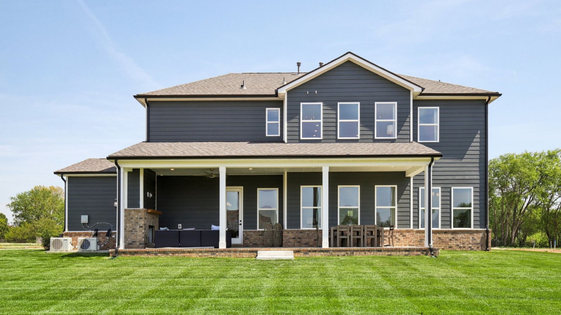 Backyard and rear of home, featuring a covered back patio with furniture and a fireplace
