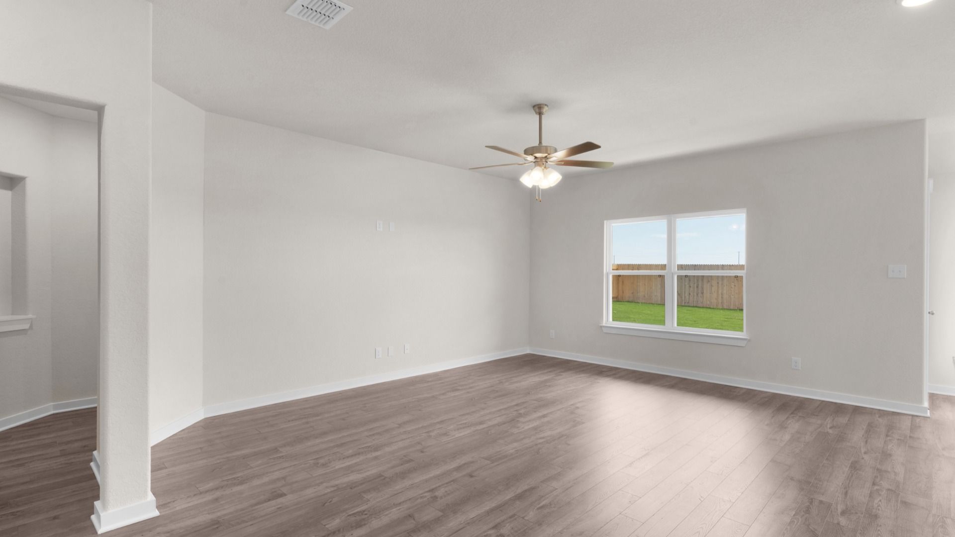 Living Area with Ceiling Fan Overlooking Backyard
