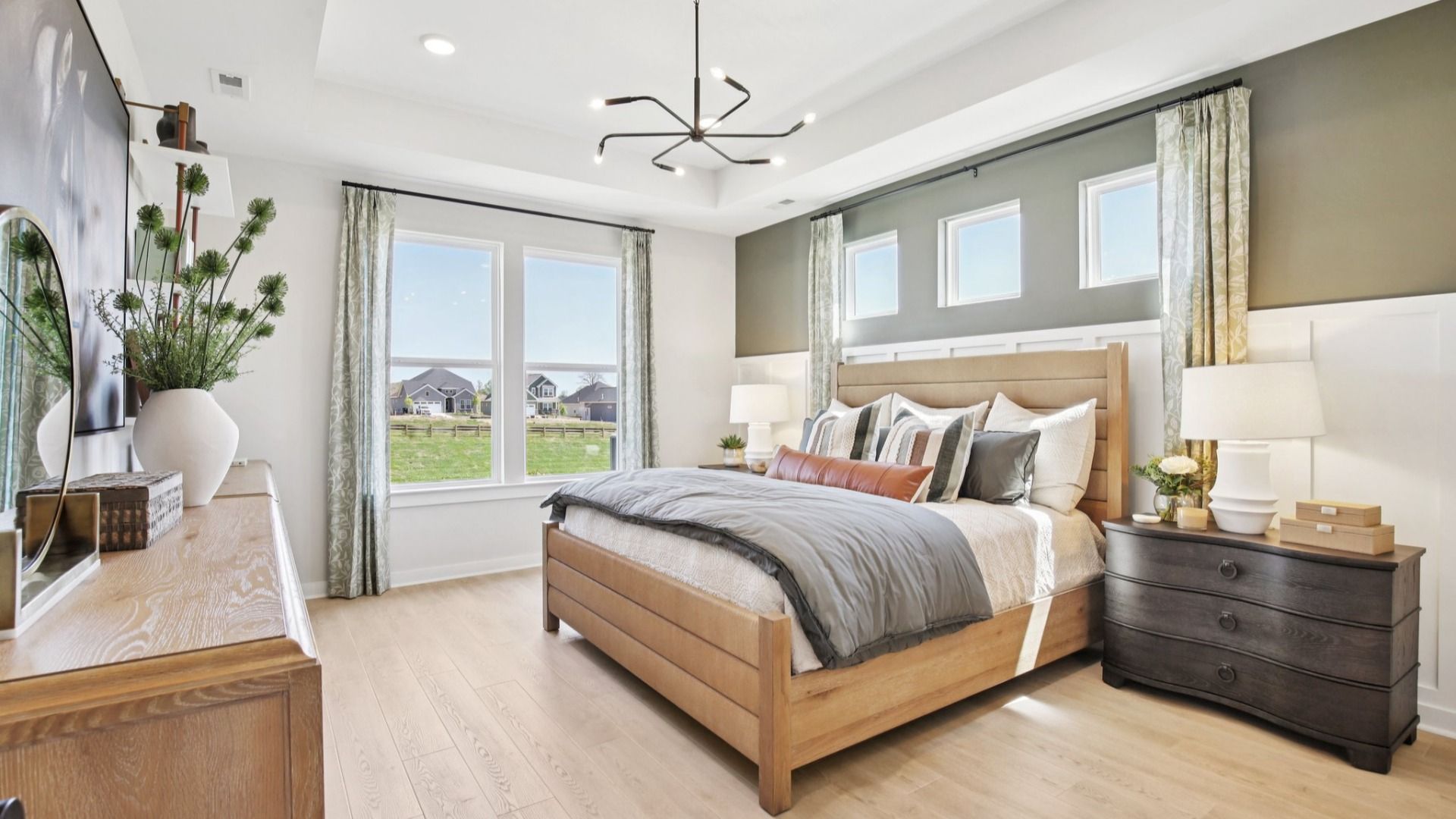 Bedroom with standard tray ceiling and abundant natural light