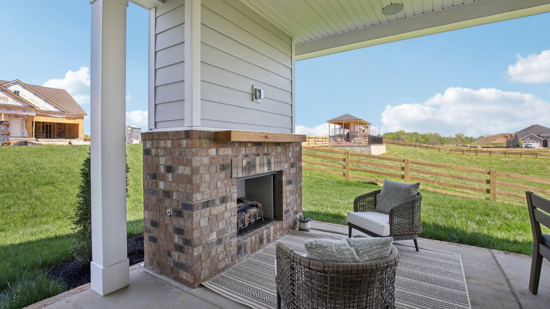 Covered Patio at the back of the home with seating area, fireplace, and outdoor dining