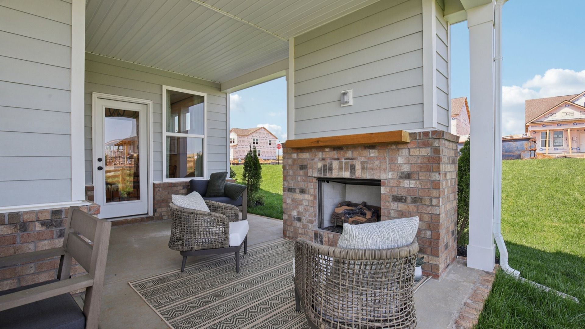 Covered Patio at the back of the home with seating area, fireplace, and outdoor dining