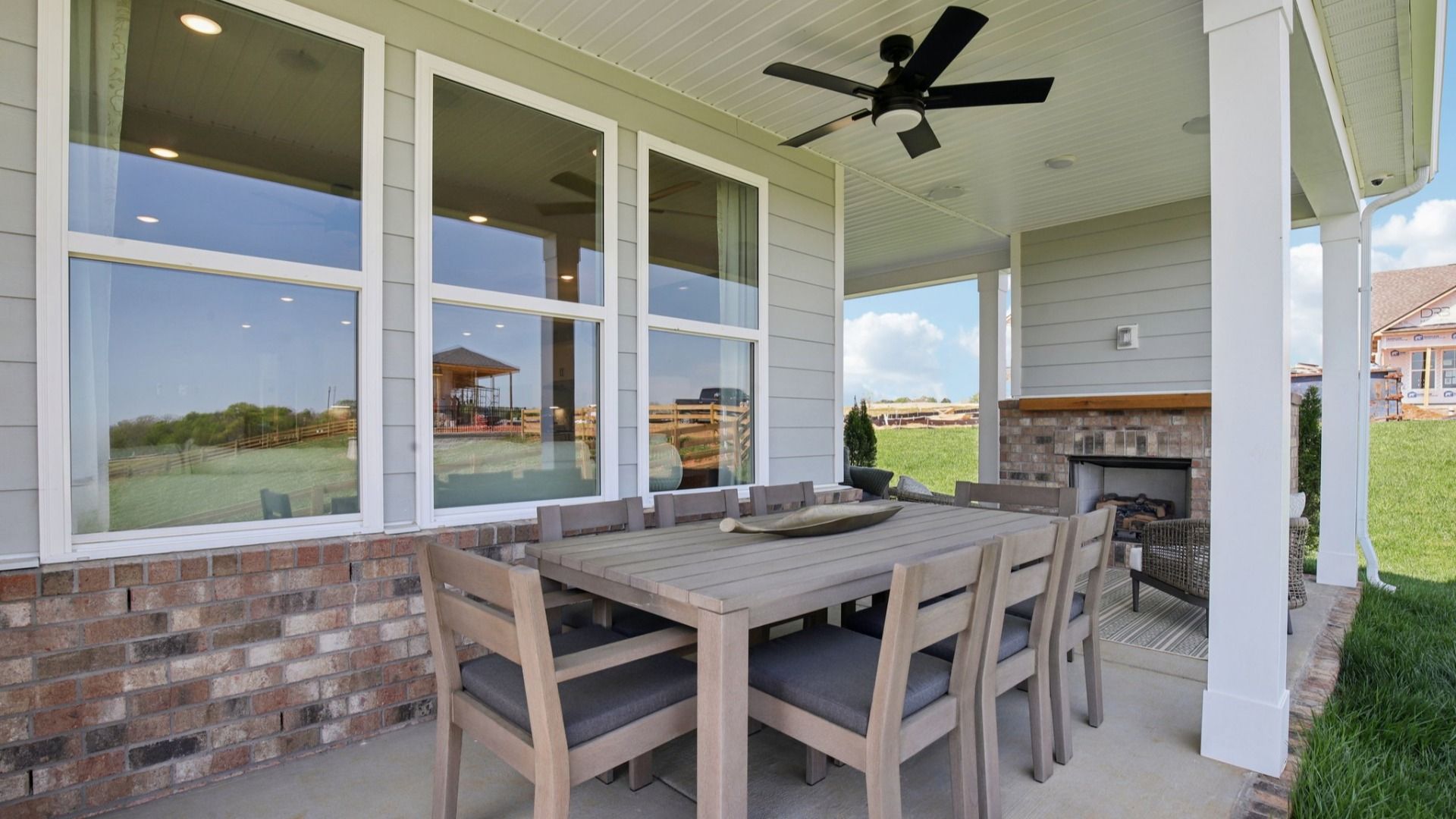 Covered Patio at the back of the home with seating area, fireplace, and outdoor dining