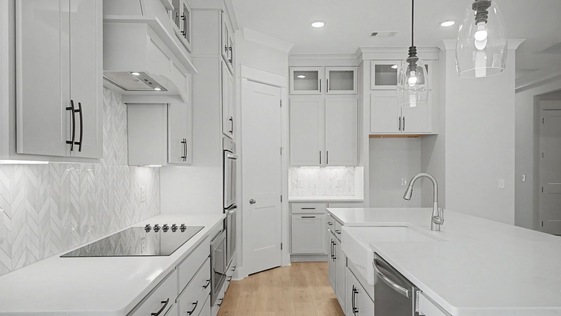 Kitchen with floor to ceiling cabinets, quartz countertops, tile backsplash, and vent hood