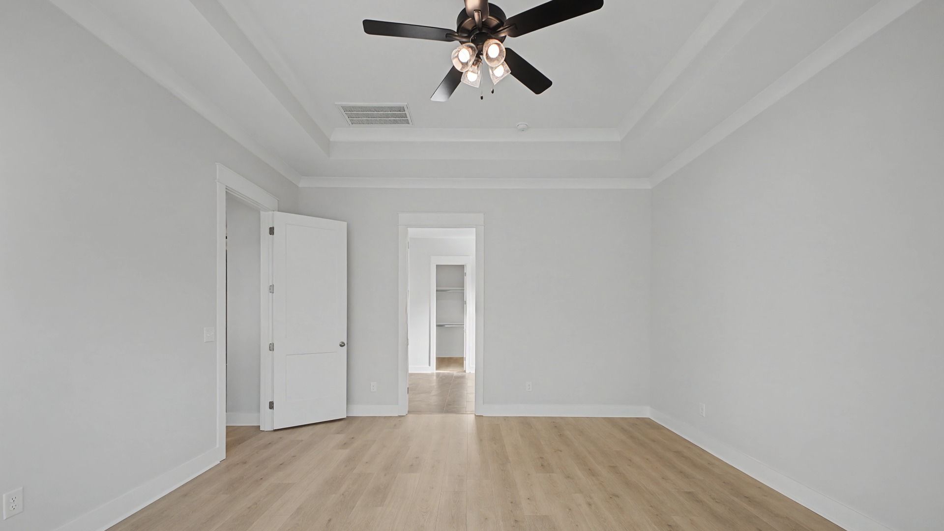 Primary Bedroom with tray ceiling, windows, and ceiling fan