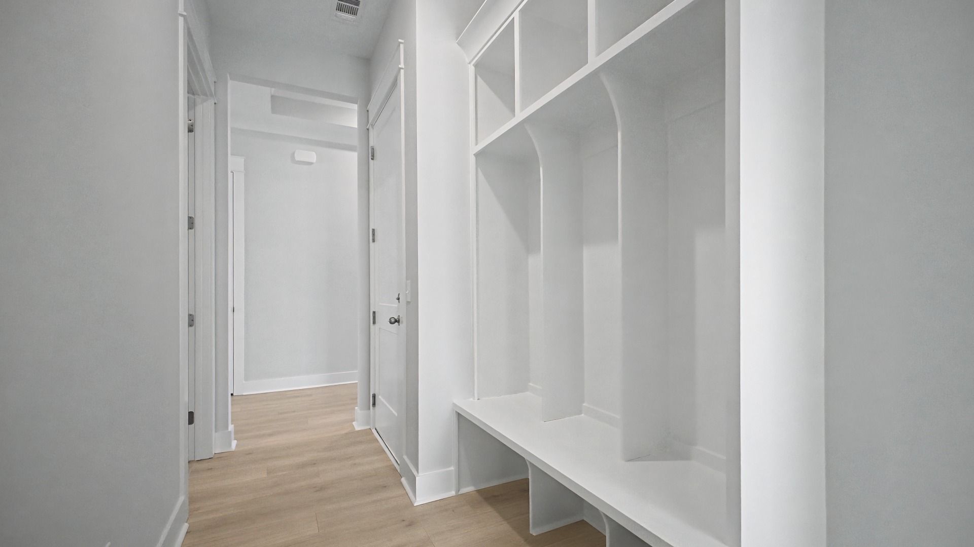 Craftsman built-in shelving and bench near garage entry