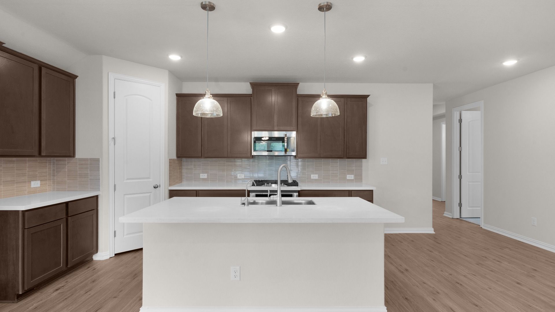 Kitchen with Ceramic Backsplash, Pendant Lighting, Gas Cooking, White Omegastone Countertops, Corner Pantry