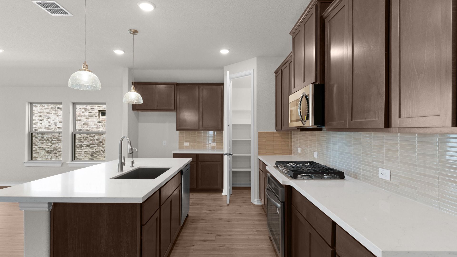 Kitchen with Ceramic Backsplash, Pendant Lighting, Gas Cooking, White Omegastone Countertops, Corner Pantry