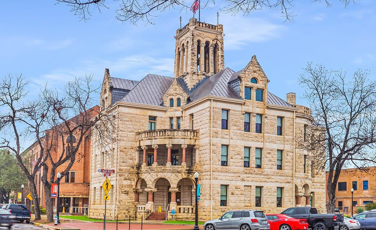 Marvel at Seguin's historic courthouse, showcasing exquisite stonework and a commanding tower. Classic urban elegance.
