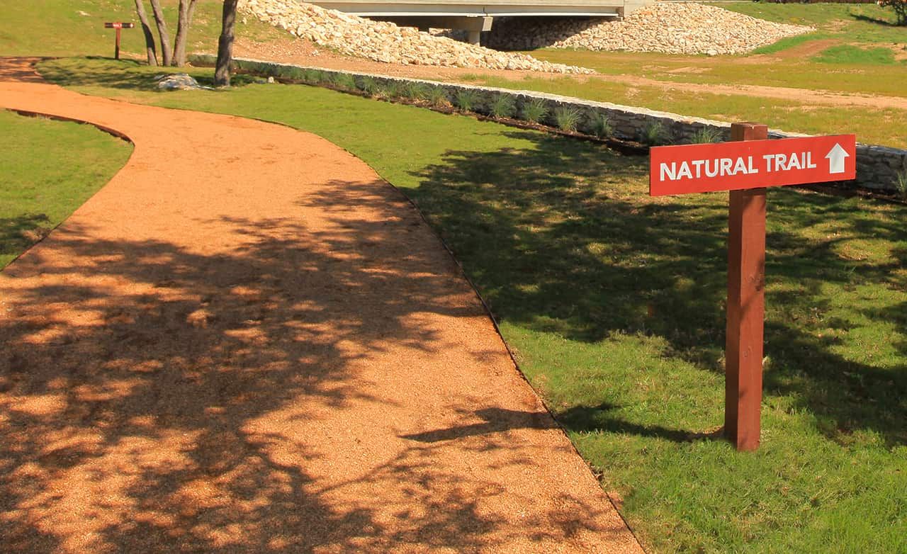 Experience serene pathways with rustic gravel trails at Meyer Ranch, Enclave, Texas.
