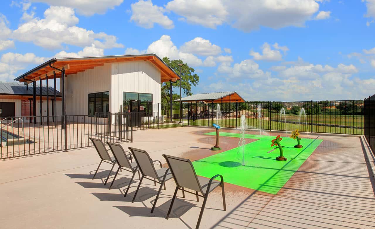 Experience luxury with the Meyer Ranch Pavilion's sleek architecture and vibrant splash pad in the Enclave.