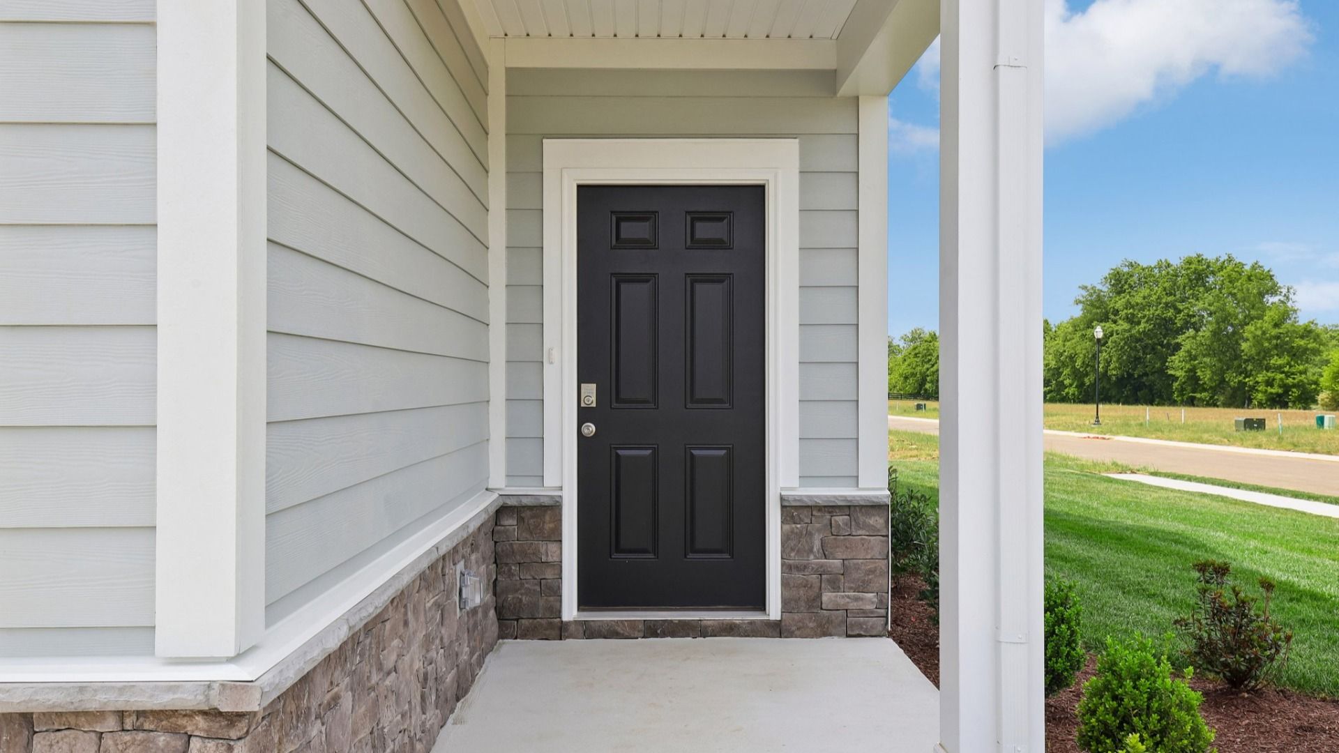 Covered Entryway to home with black door