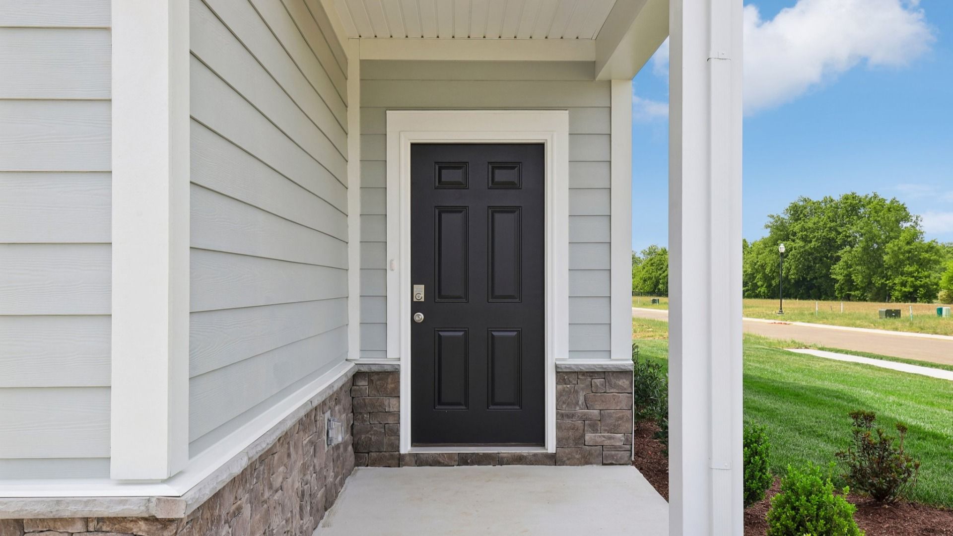 Covered Entryway to home with black door