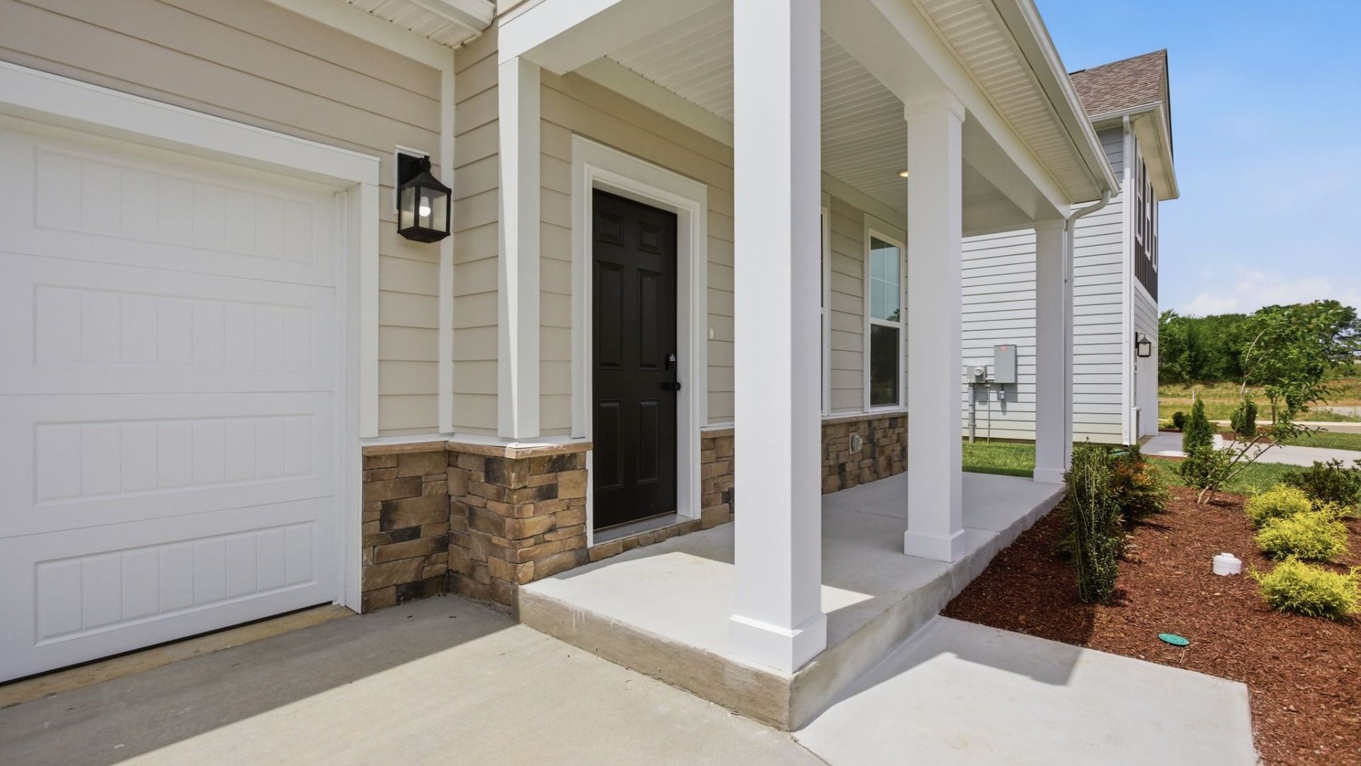 Covered entryway to home with black door