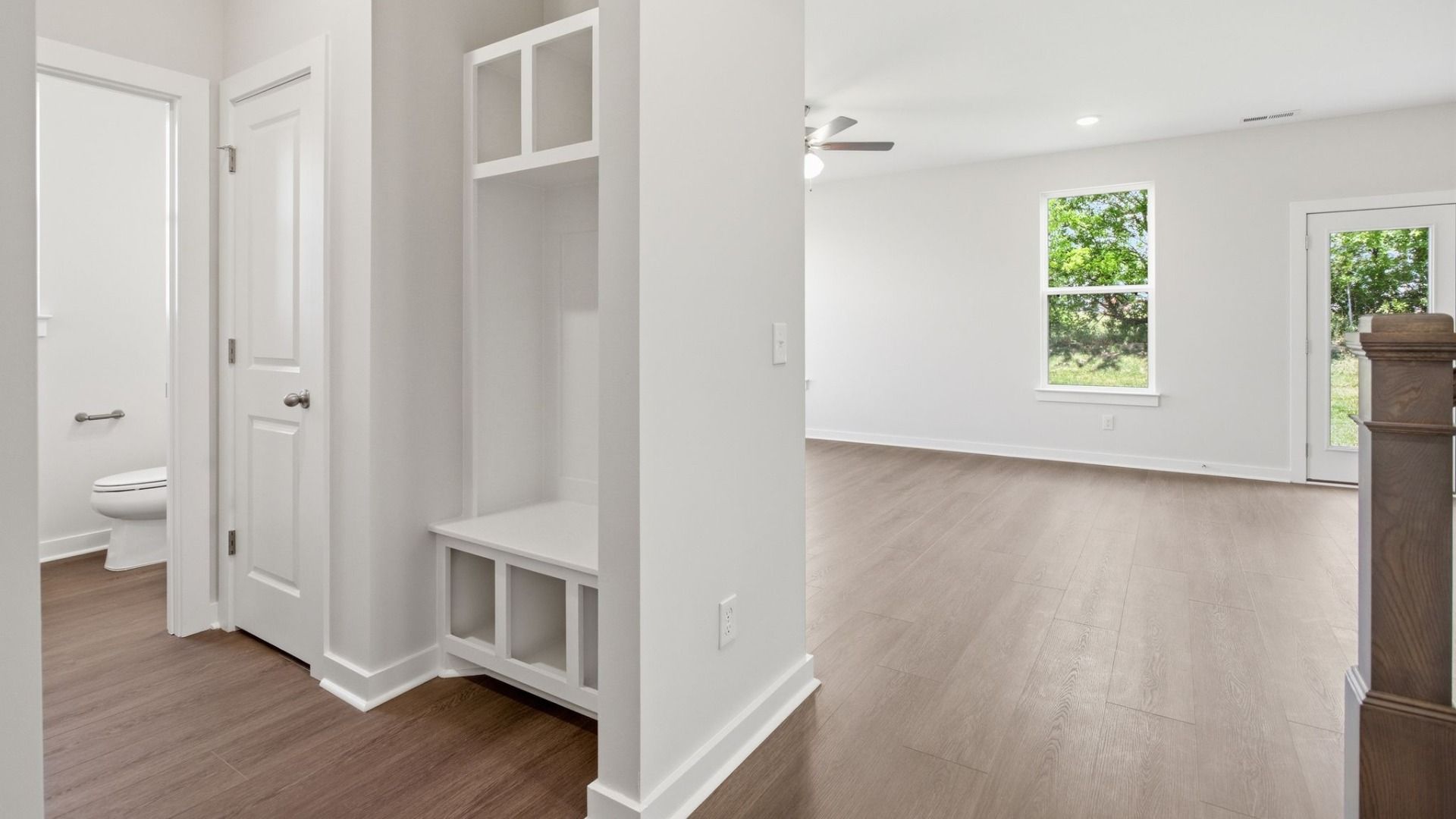 The powder room and Drop-zone with a linen closet, view of dining area and rear door