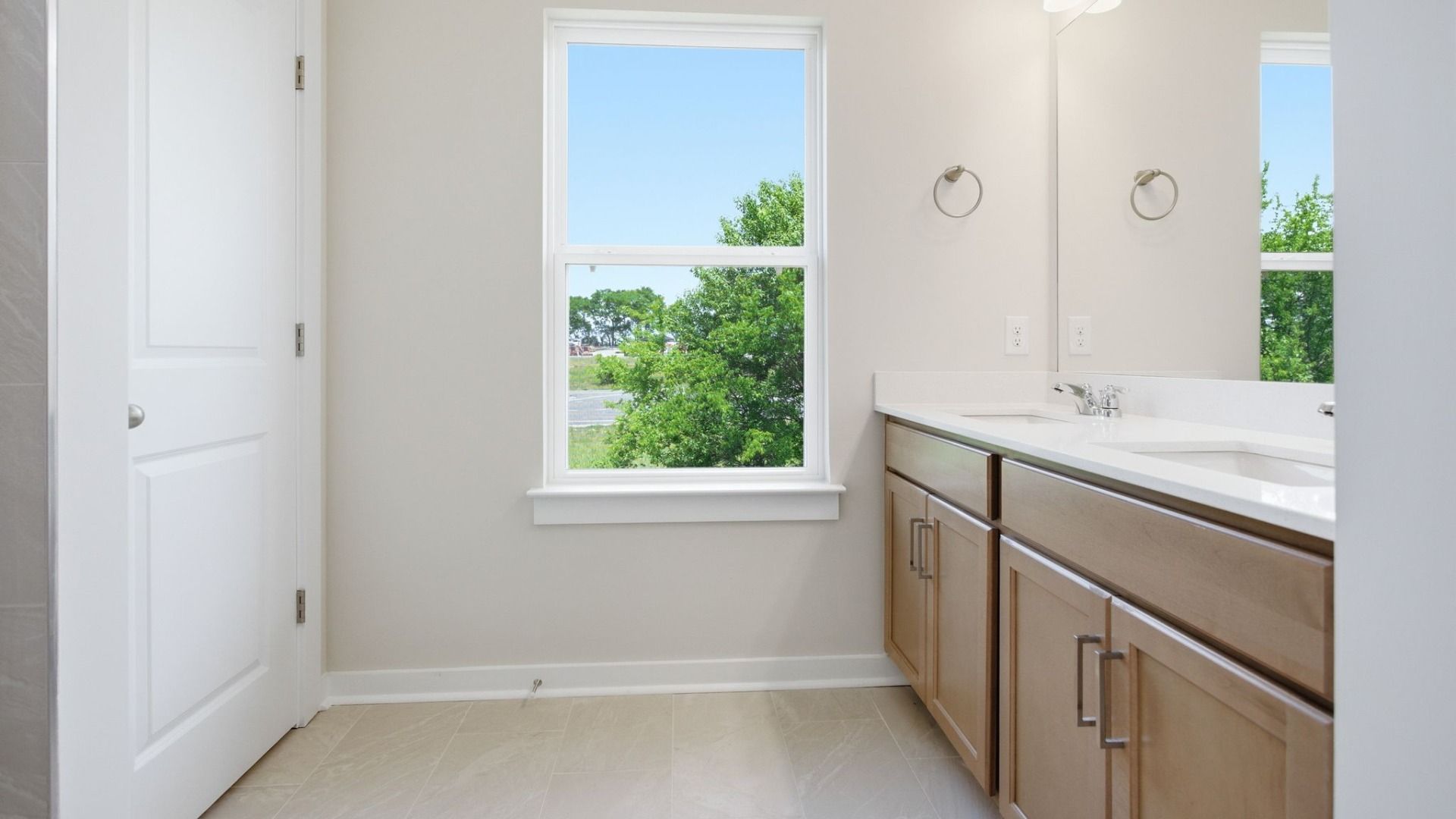 Bathroom with window, double vanity, and hard surface flooring