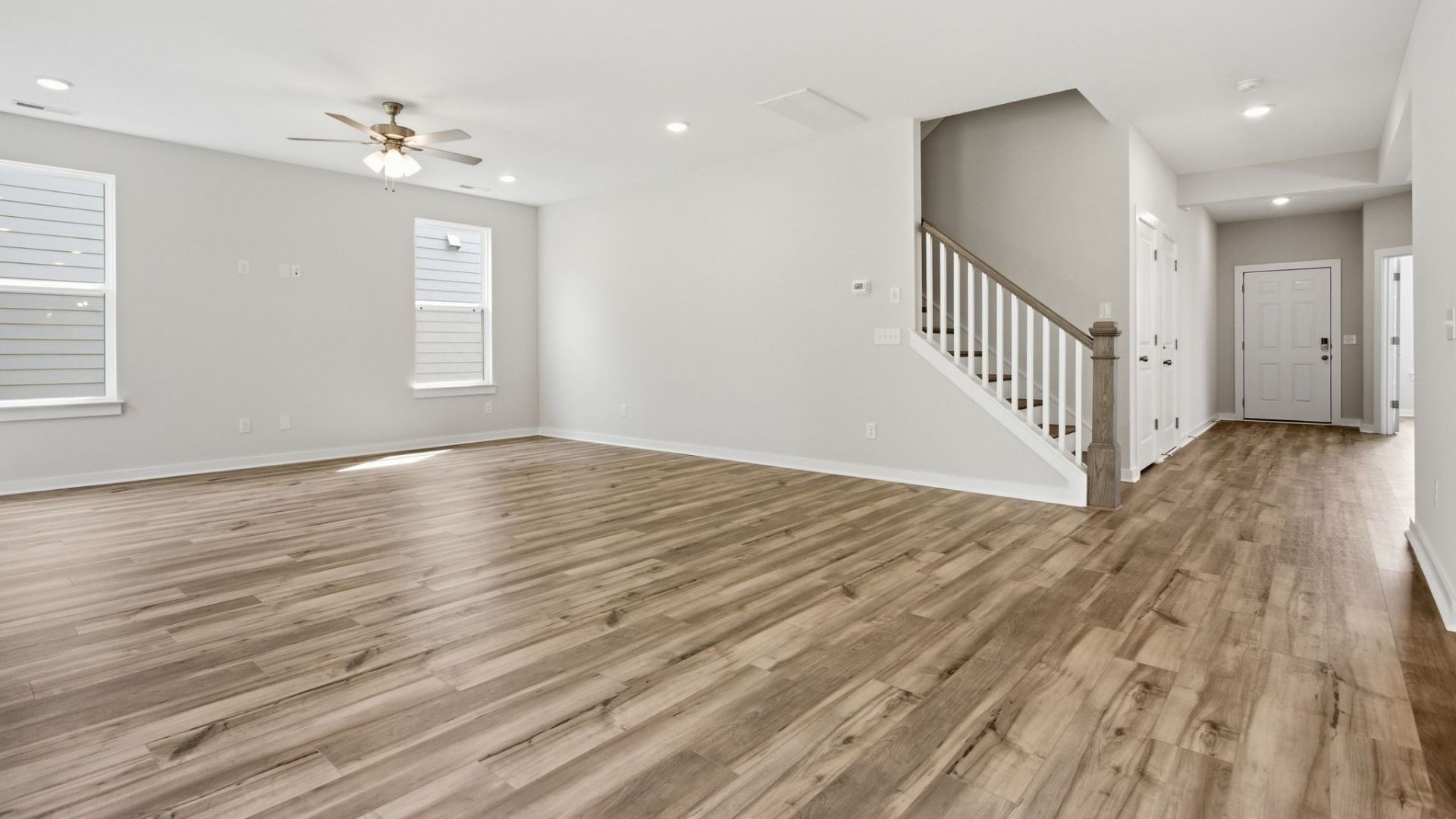 First floor with hard surface flooring, windows, and nearby staircase