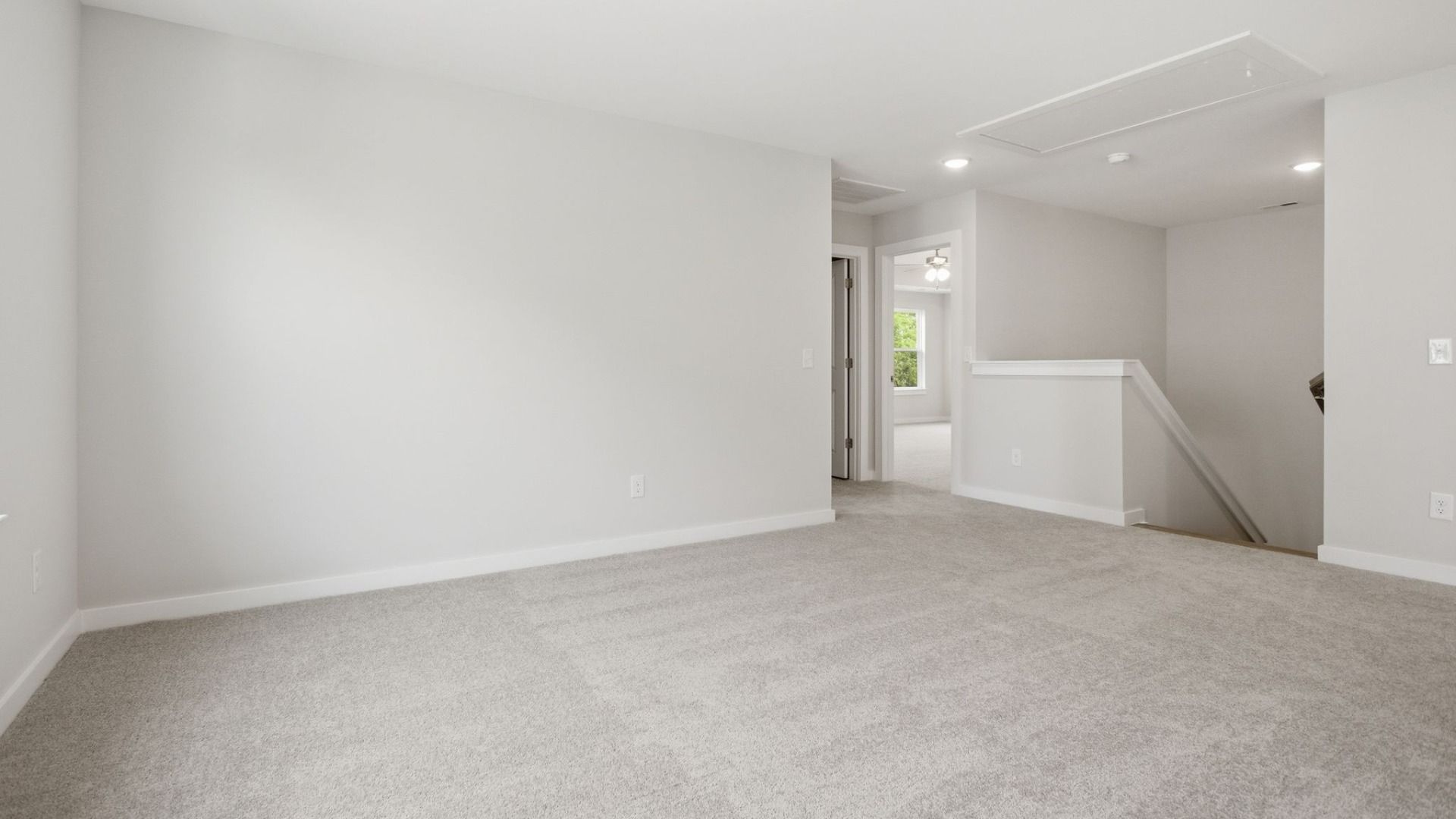 Second Floor Loft area with view of stairs, access to dedicated laundry room, and access to primary suite