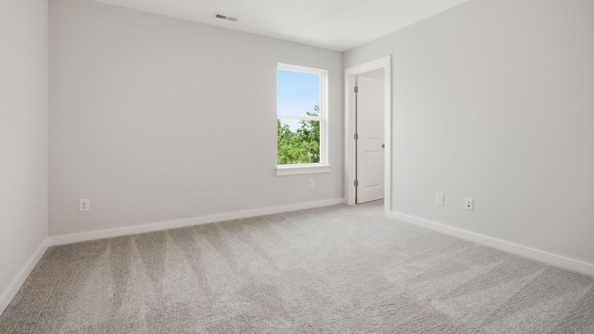 Bedroom with carpet, window, and walk-in closet