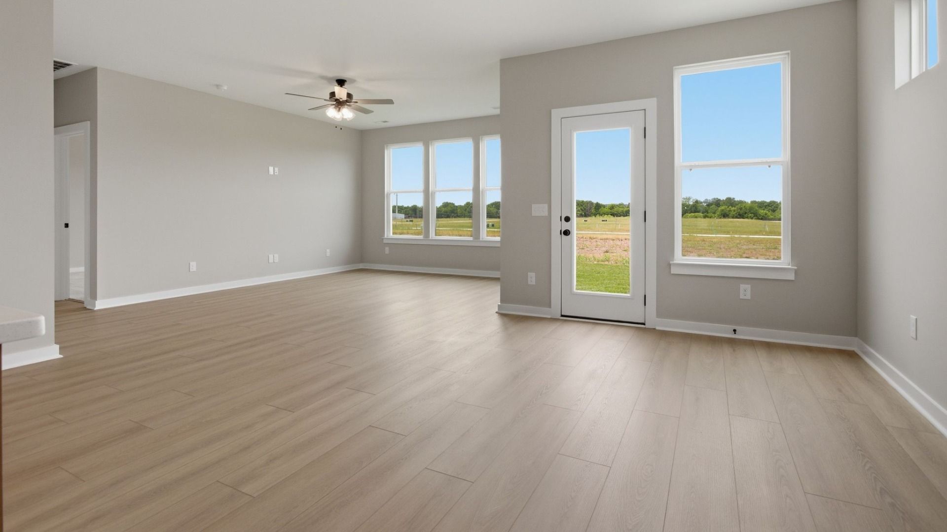 Gathering and dining area with access to back entry and bright natural light through windows