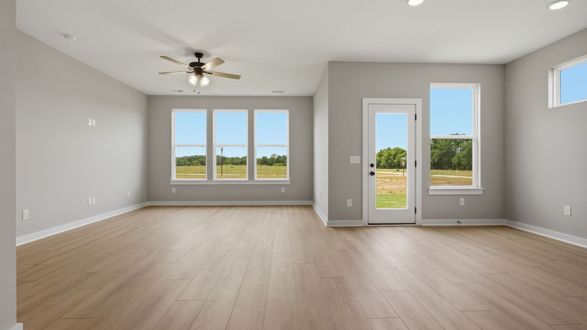 Gathering and dining area with access to back entry and bright natural light through windows