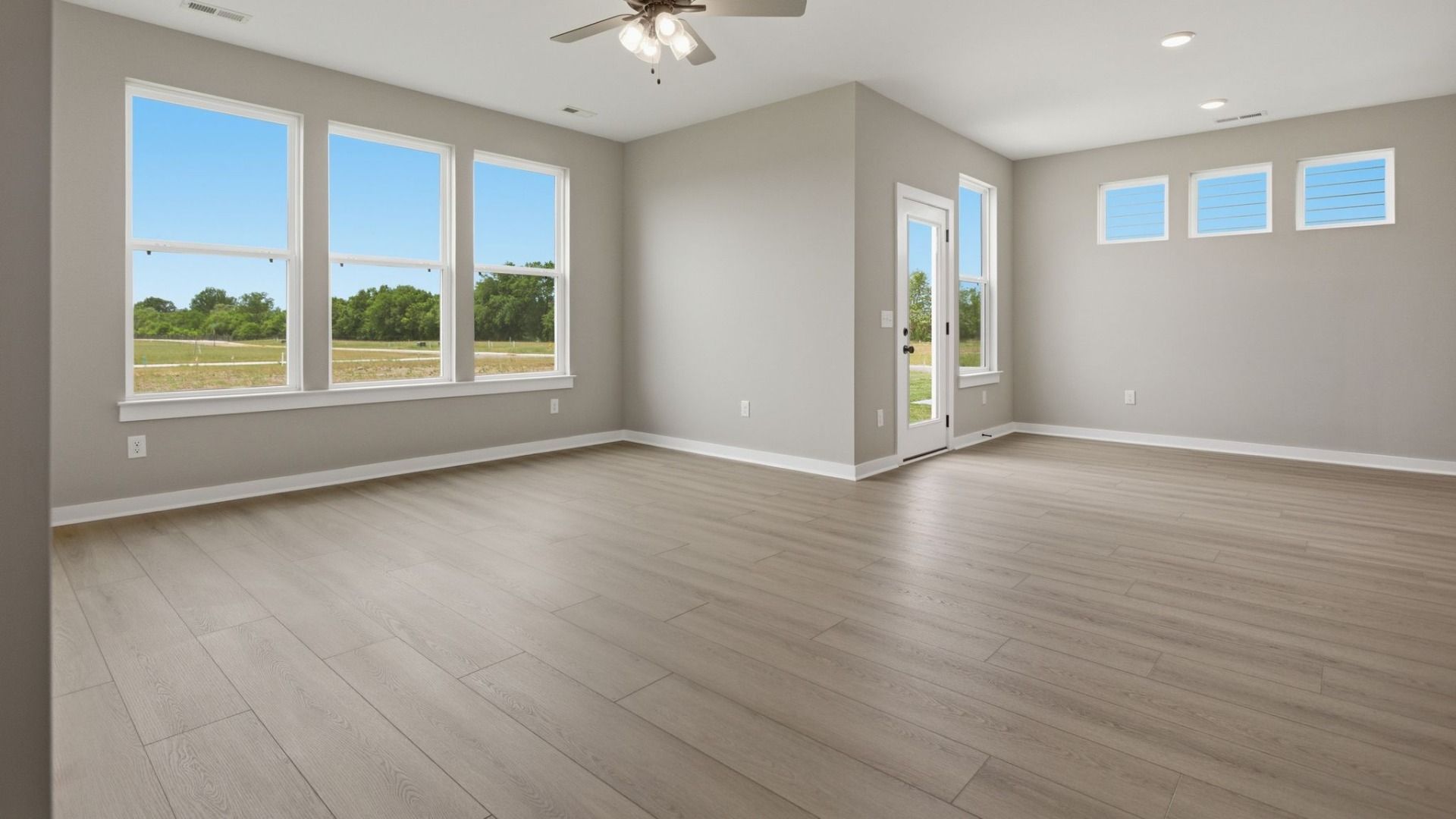 Gathering and dining area with access to back entry and bright natural light through windows