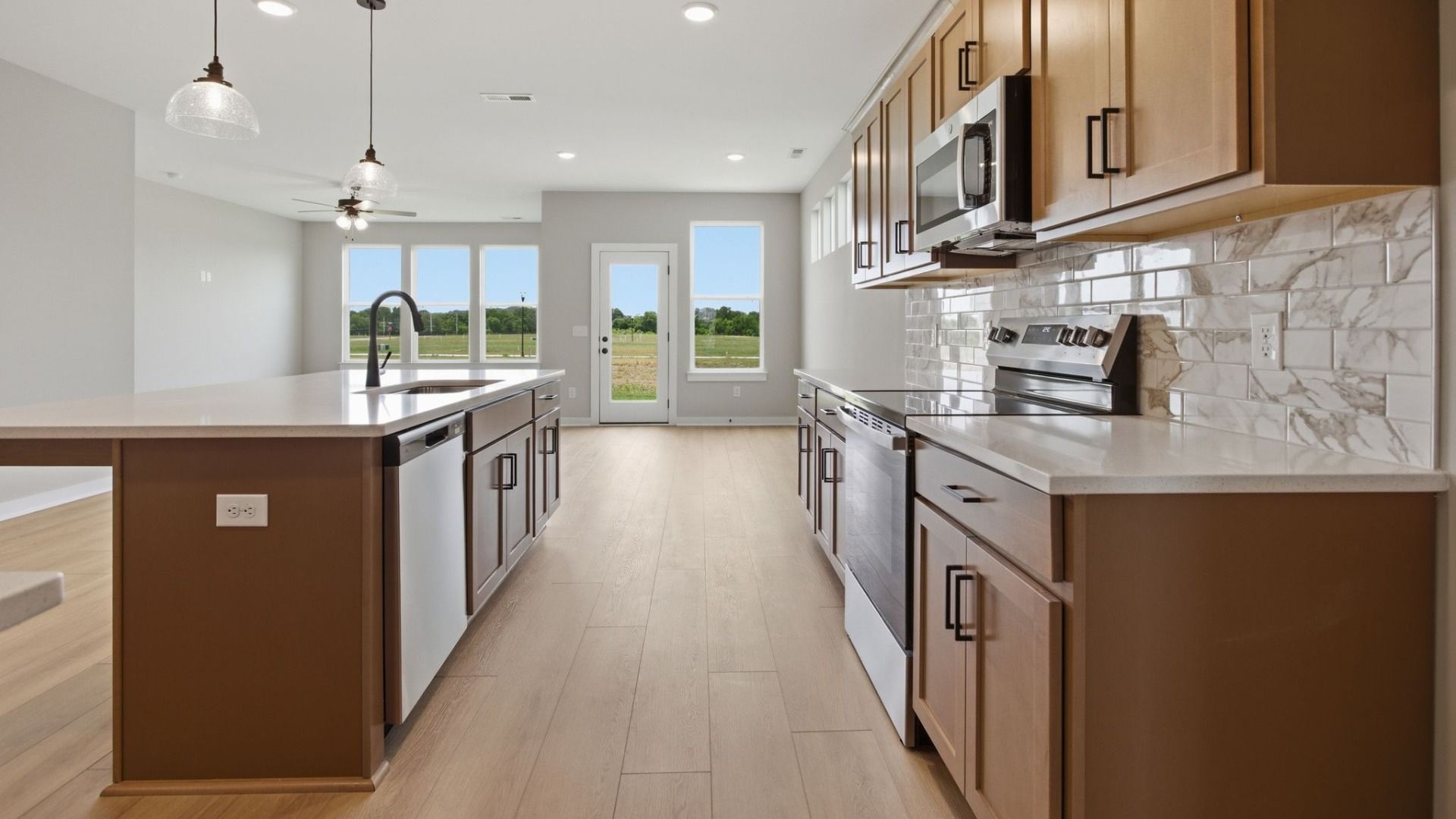 Kitchen with quartz countertops, tile backsplash, and view of gathering room