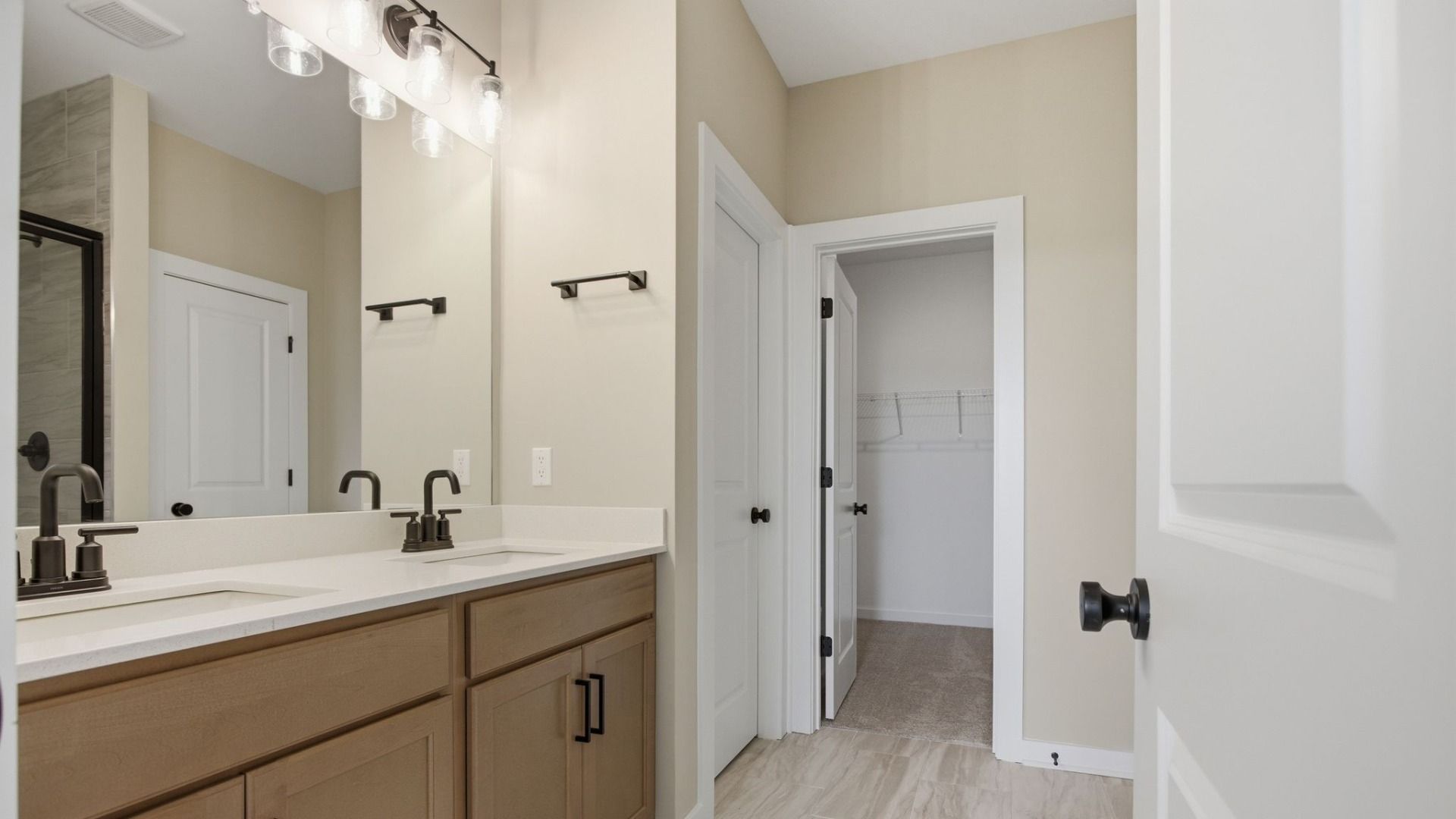 Bathroom with dual vanity and access to closet