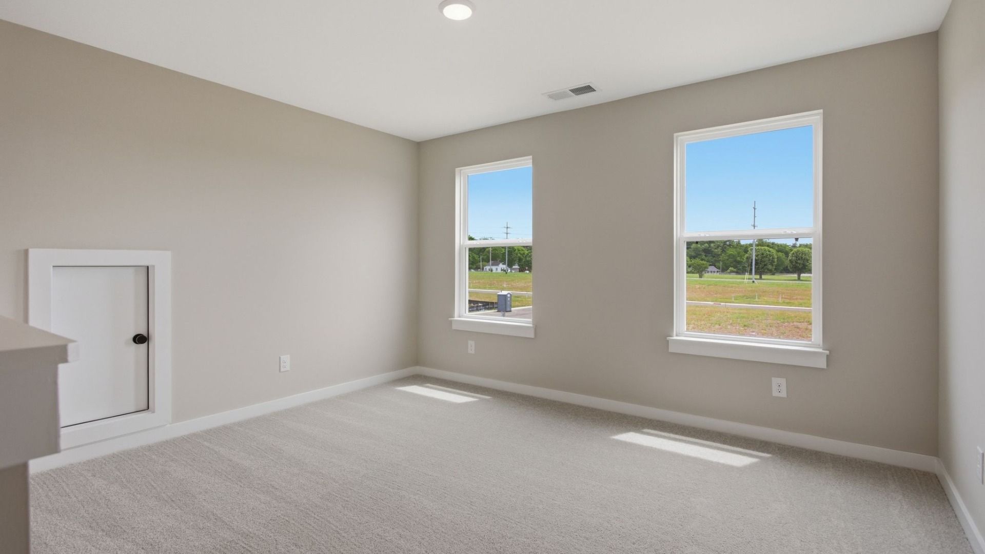 Loft with carpet, windows, and attic access