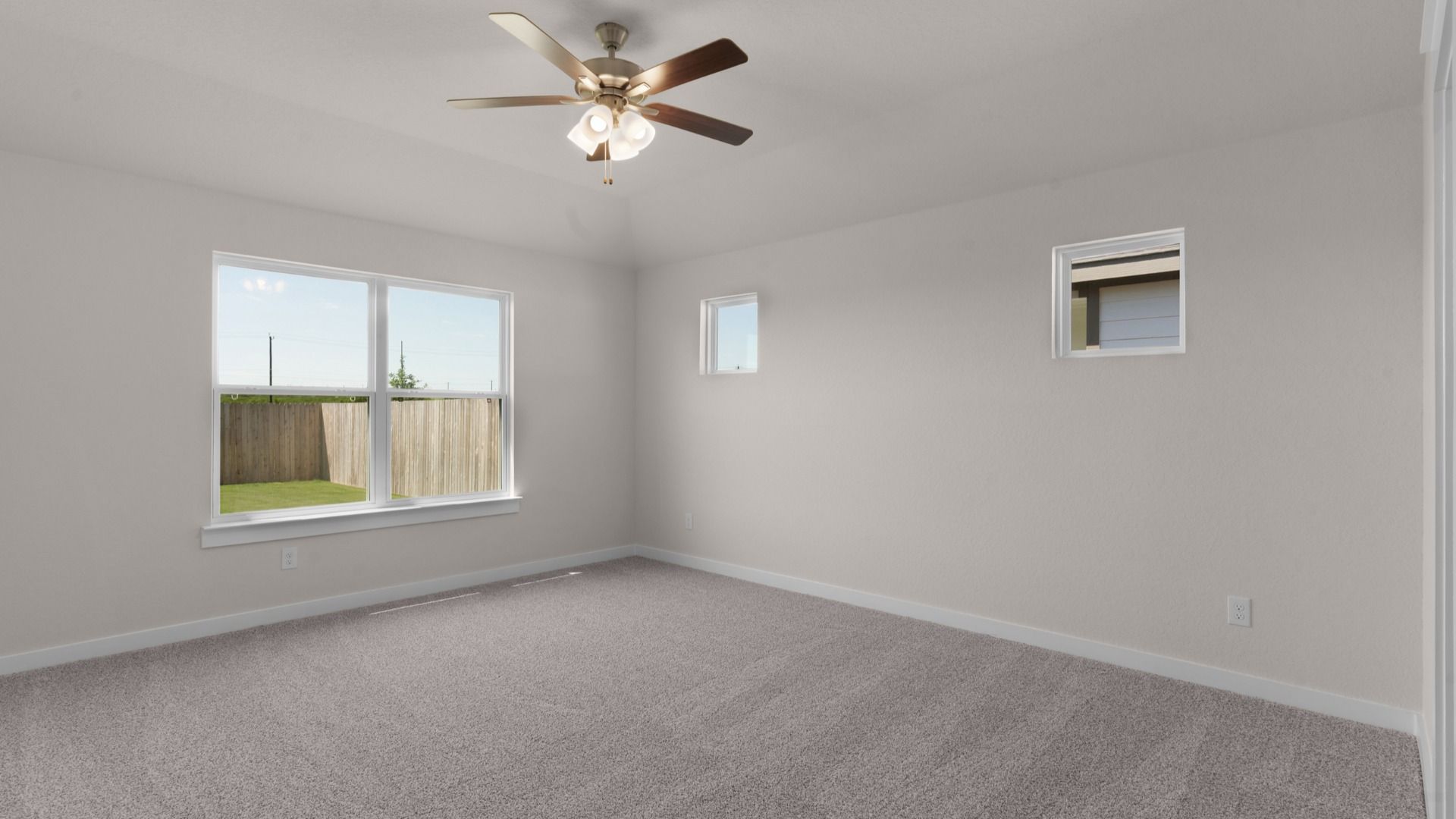 Owner’s suite with ceiling fan and a window overlooking the backyard, creating a relaxing retreat.