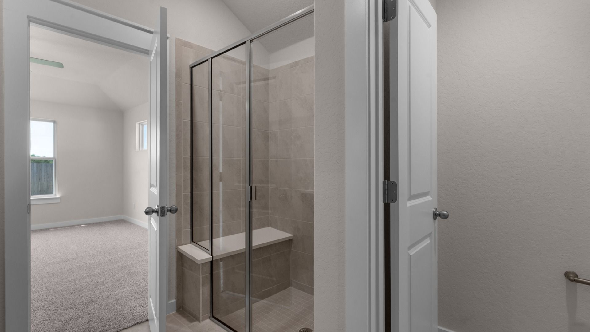 Dual vanity, a framed glass shower with built-in seat, blending style and practical function.