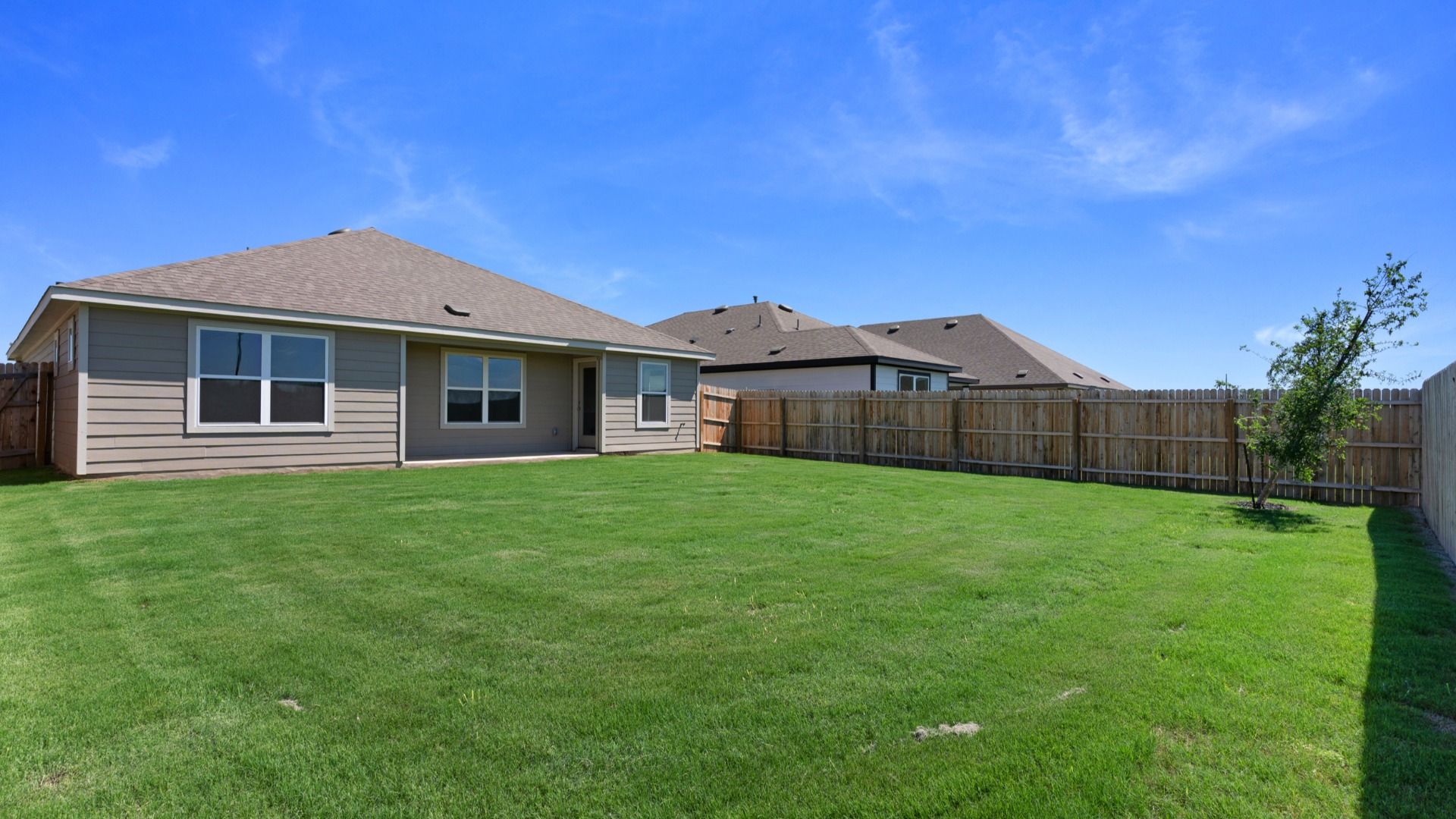 Ample backyard space with a covered patio, offering room to relax, play, and entertain outdoors.