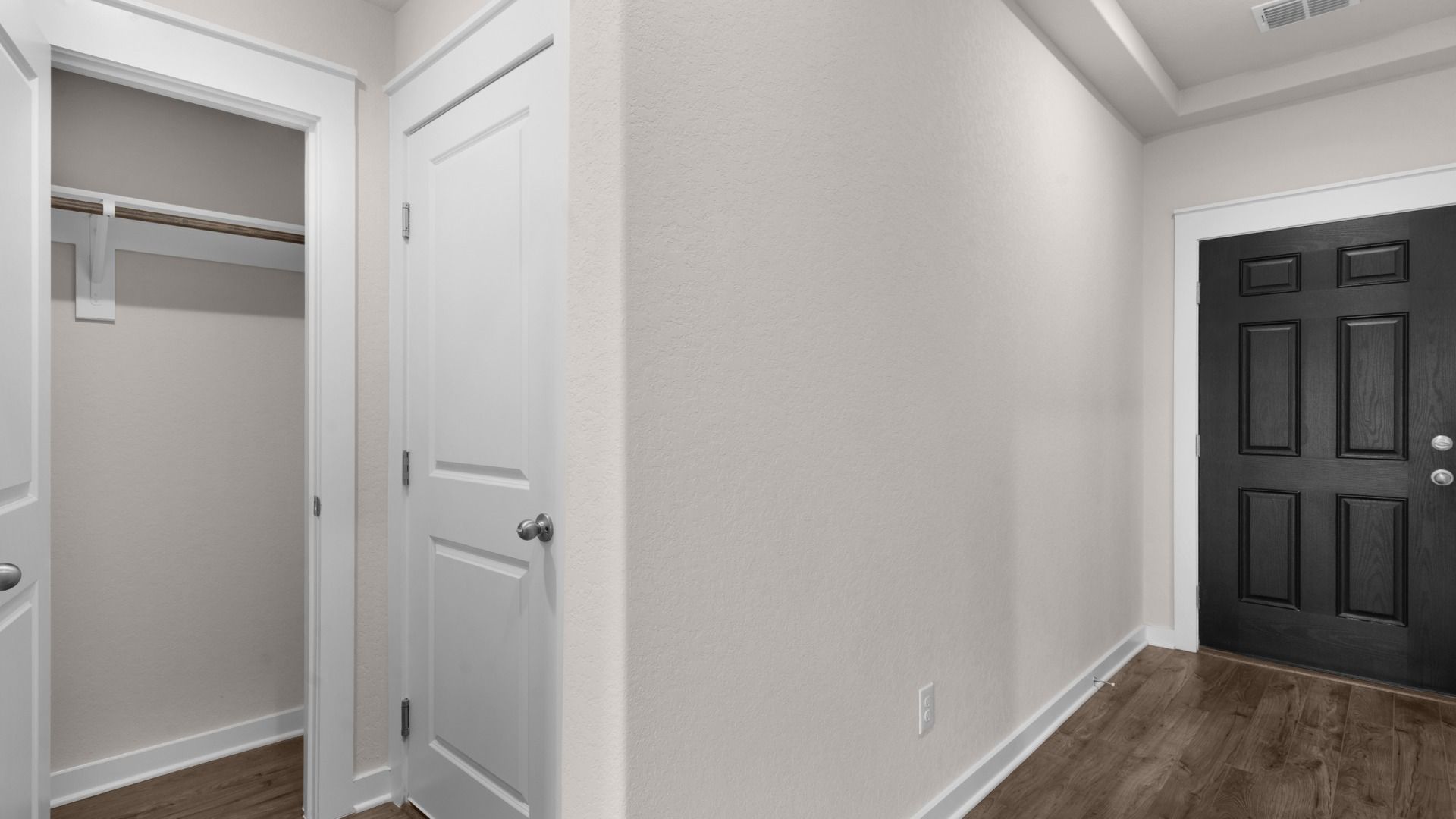 Entryway with tray ceilings and a convenient coat closet, creating a spacious and organized welcome space.