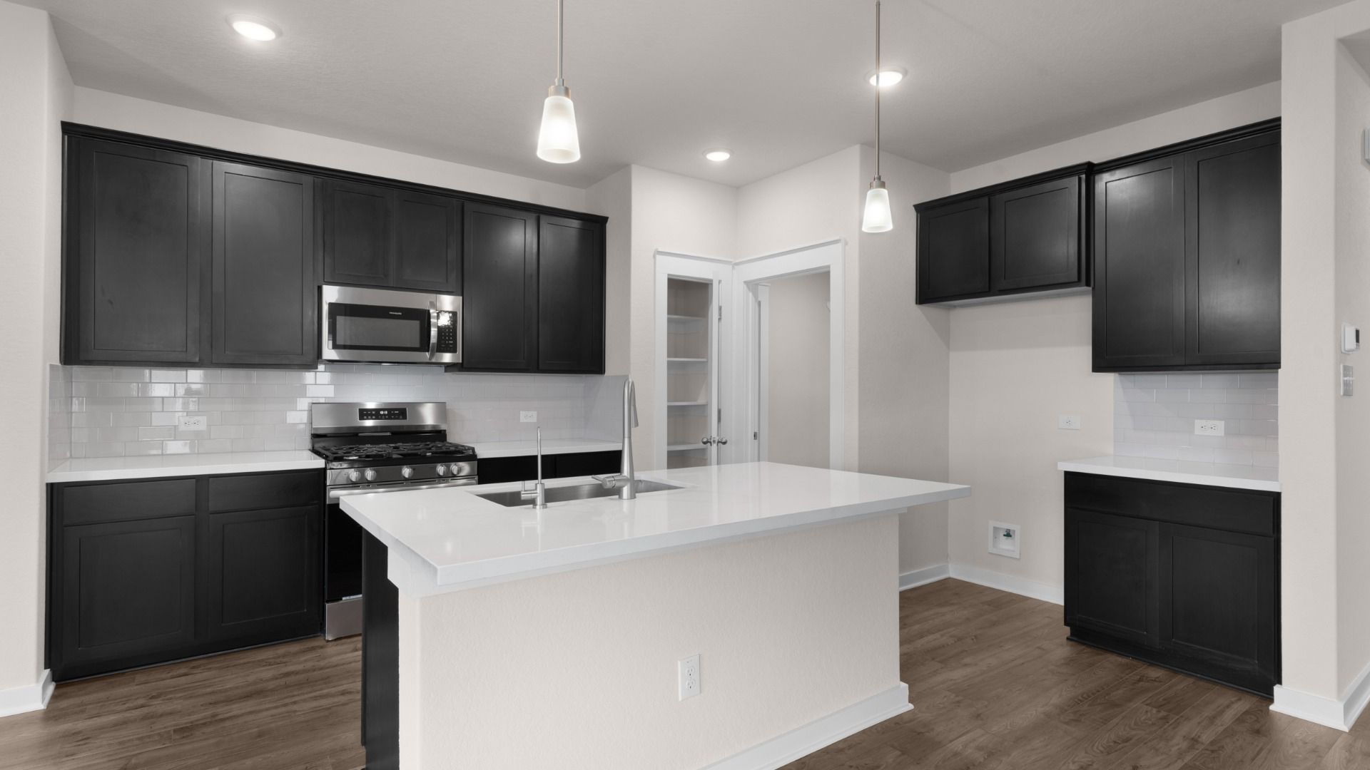 Kitchen features 42-inch cabinets, pendant lighting, and a spacious center island for cooking and gathering.