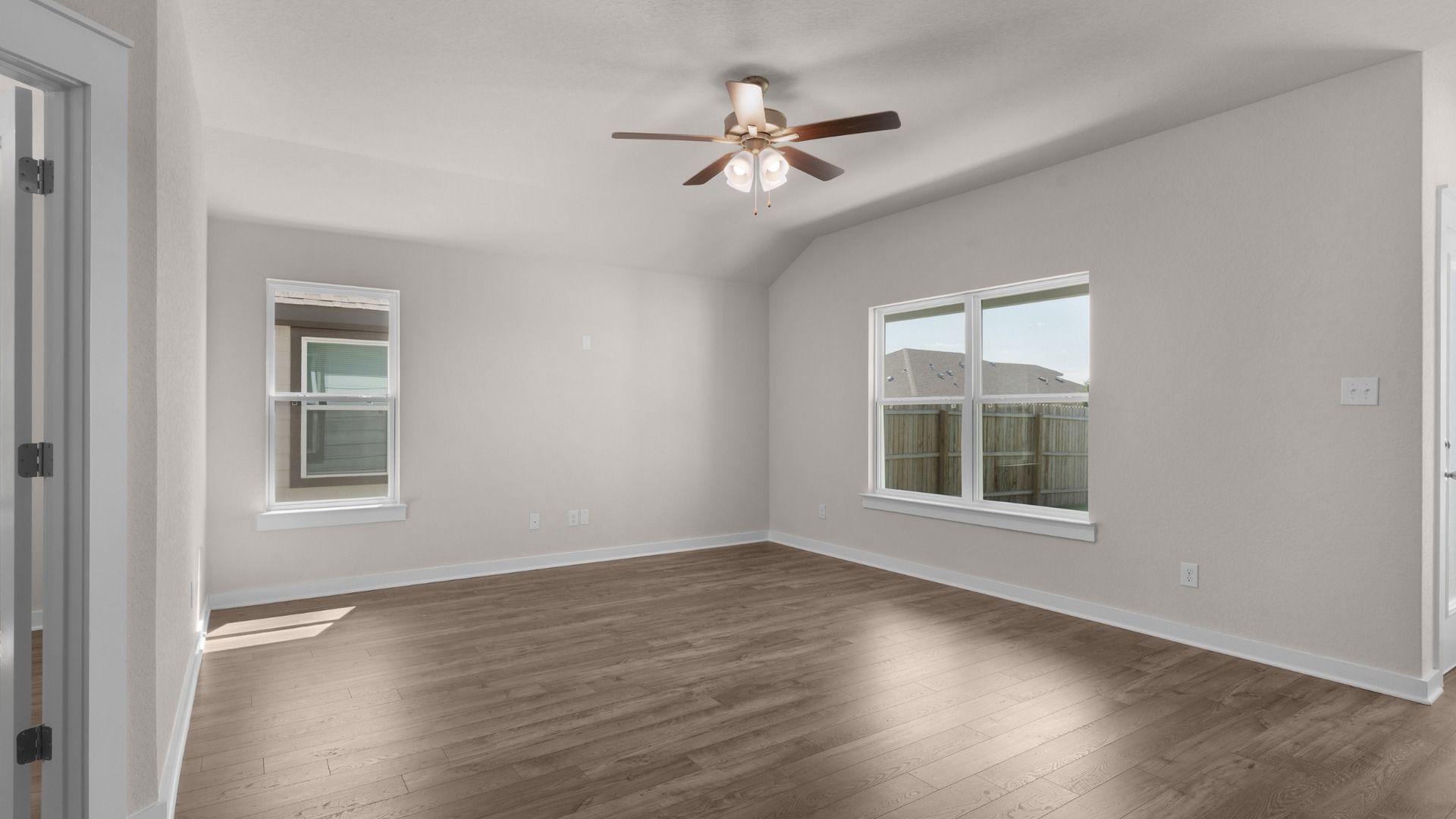 Great room with ceiling fan and large windows, filling the space with natural light and comfortable airflow.