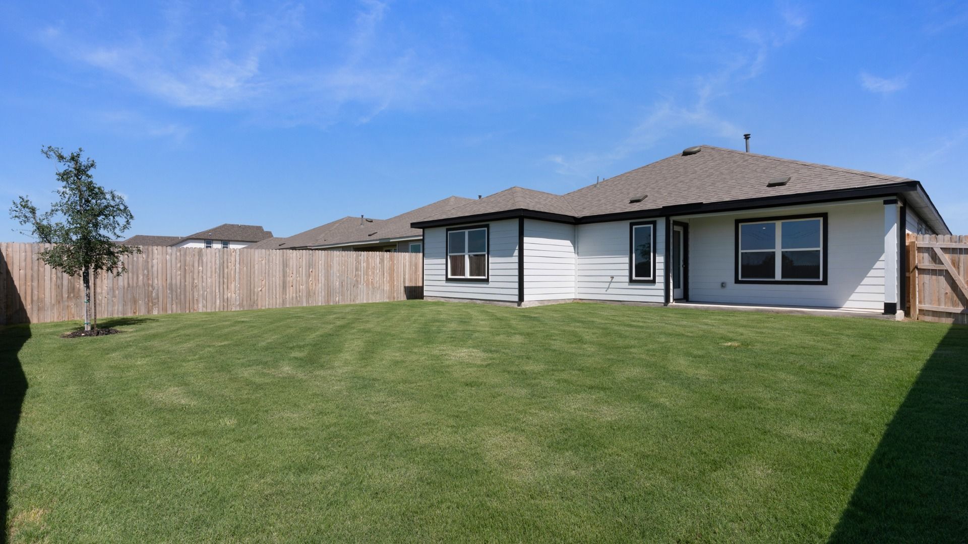 Ample backyard space with a covered patio, offering room to relax, play, and entertain outdoors.