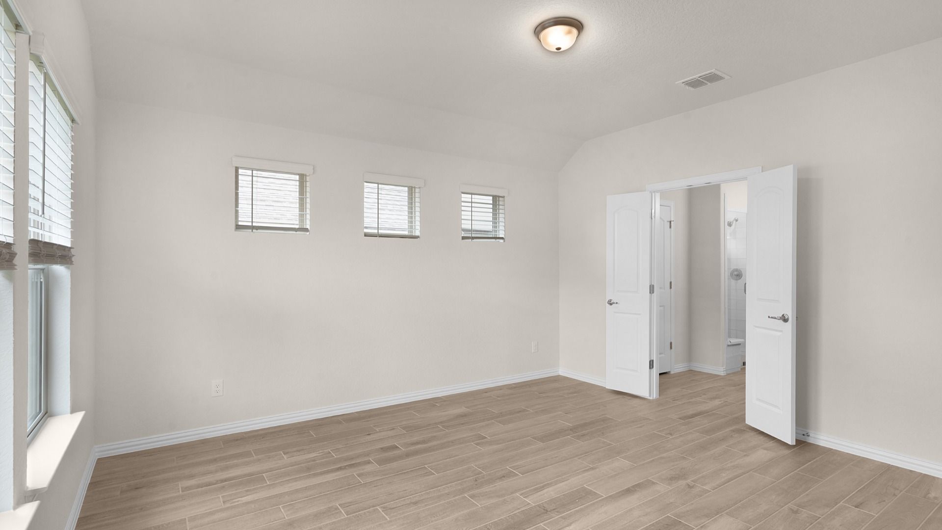 Owner’s suite features no carpet, blinds, and double doors opening to the private owner’s bath.
