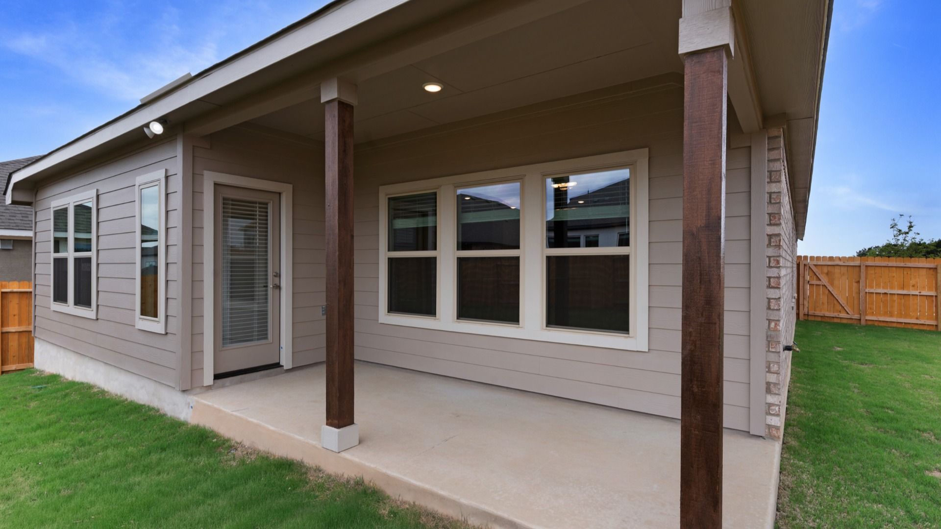 Covered patio with wooden posts adds architectural detail and a comfortable outdoor living space.