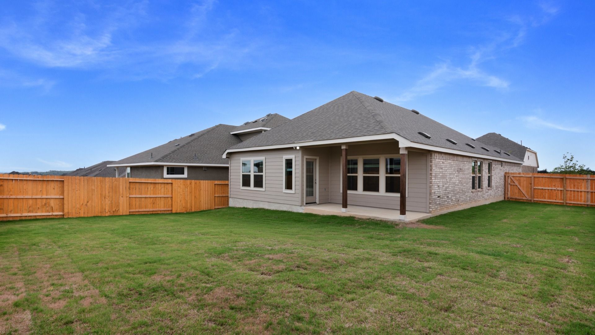 Covered patio with wooden posts adds architectural detail and a comfortable outdoor living space.