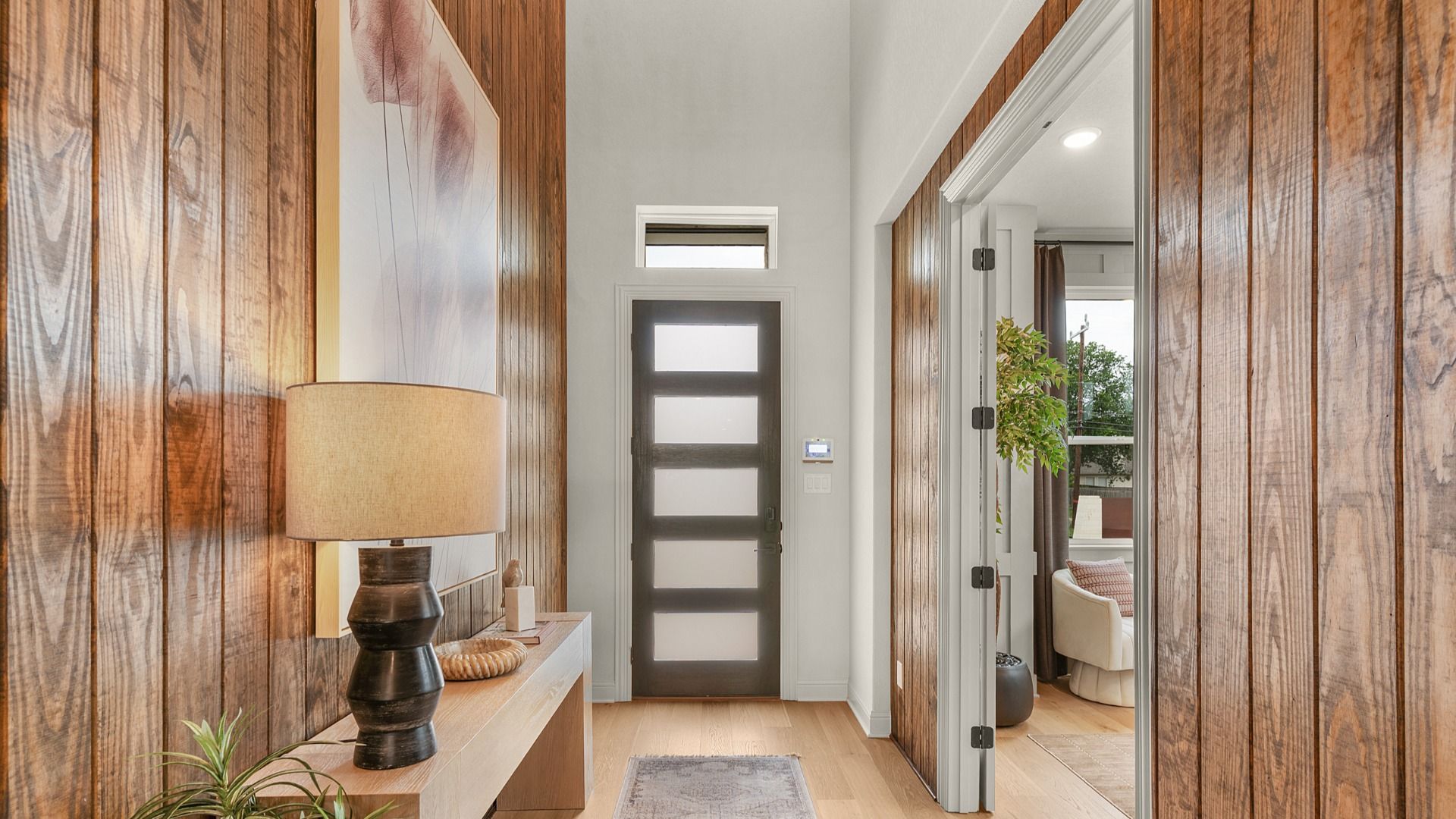 Modern entryway with soaring ceilings, natural light, and sleek finsih.