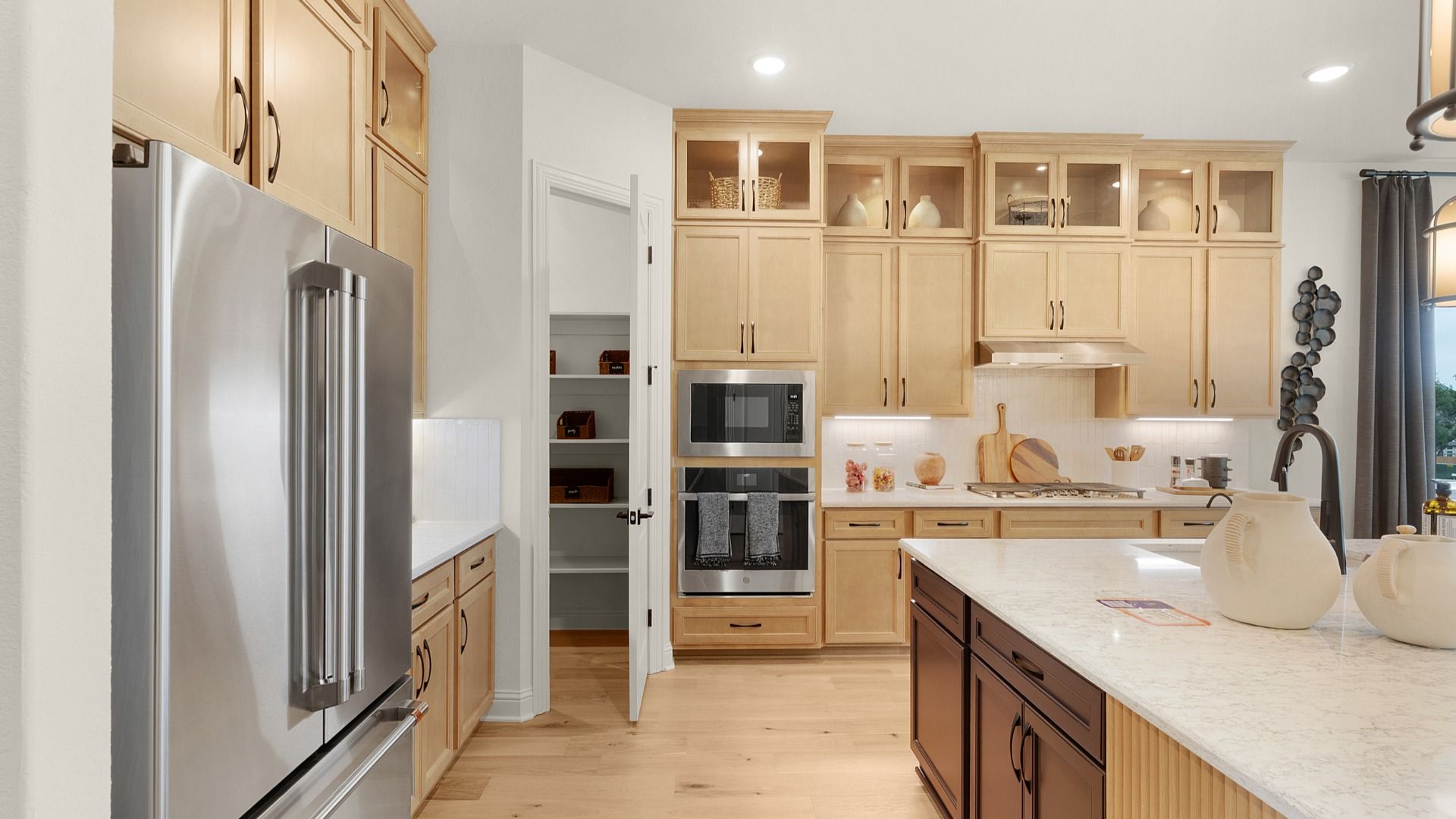 Modern kitchen with spacious corner pantry, cabinet accent lighting, and warm tones