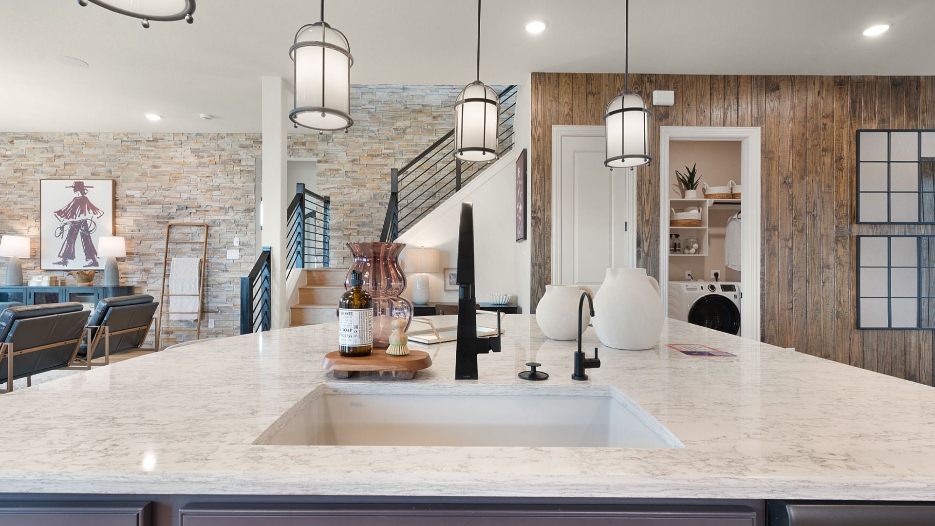 Open kitchen overlooking the great room with views of the staircase leading to the second floor.