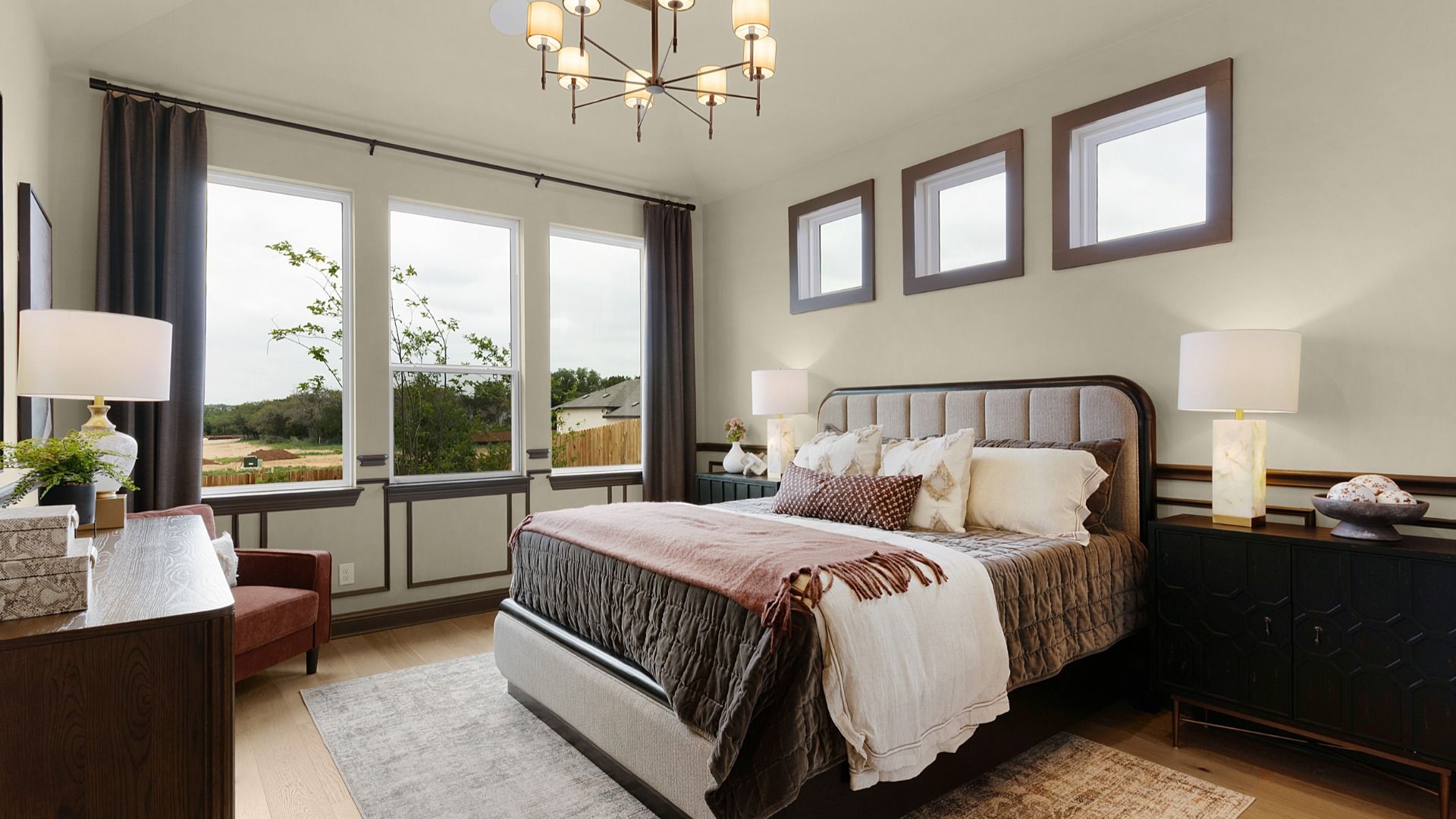Owner’s suite with abundant natural light, woodwork details, and warm-toned flooring for a refined feel.