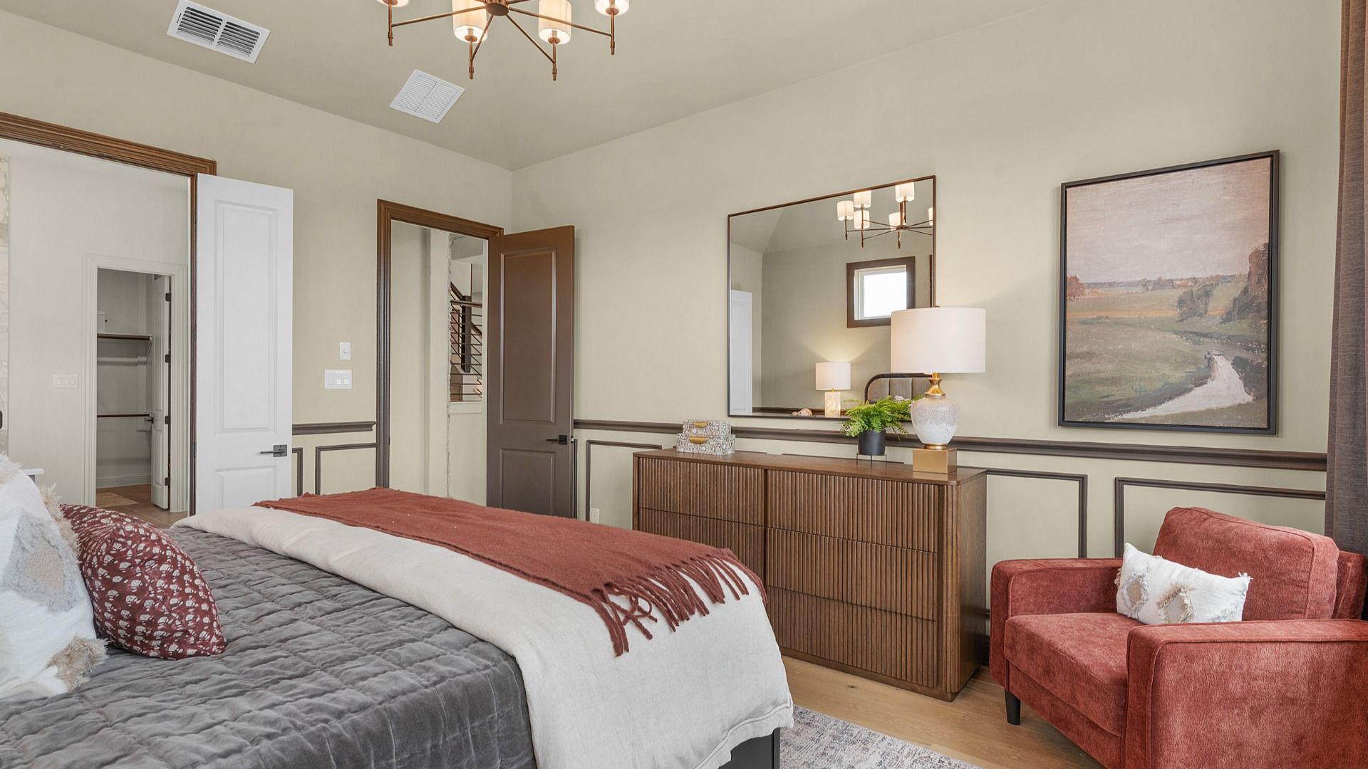 Owner’s suite with abundant natural light, woodwork details, and warm-toned flooring for a refined feel.